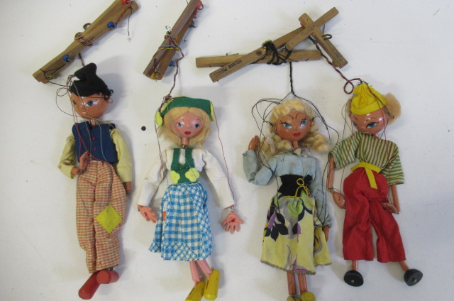 Four unboxed Pelham puppets of girls in traditional costumes Image