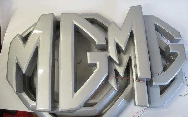 A large car dealership M.G. badge/sign finished in plastic and Image