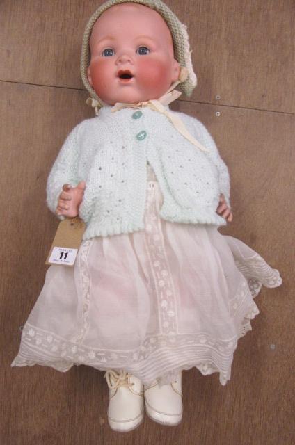 An Armand Marseille bisque socket head baby doll with fixed blue glass eyes and open mouth Image