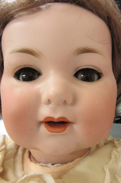 An Armand Marseille bisque socket head baby doll with fixed blue glass eyes and open mouth Image