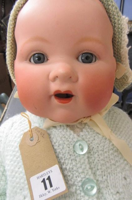 An Armand Marseille bisque socket head baby doll with fixed blue glass eyes and open mouth Image