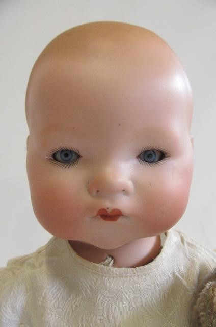 An Armand Marseille bisque flange neck baby doll with blue glass sleeping eyes Image