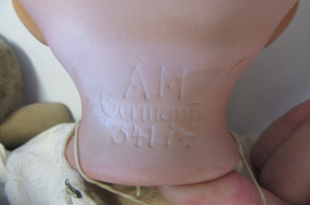 An Armand Marseille bisque flange neck baby doll with blue glass sleeping eyes Image