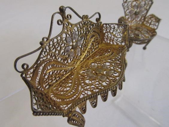 A set of five bi-colour silver filigree dolls house items comprising a settee and two matching Image