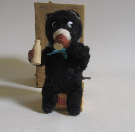 A plush covered clockwork bear with milk drinking action Image