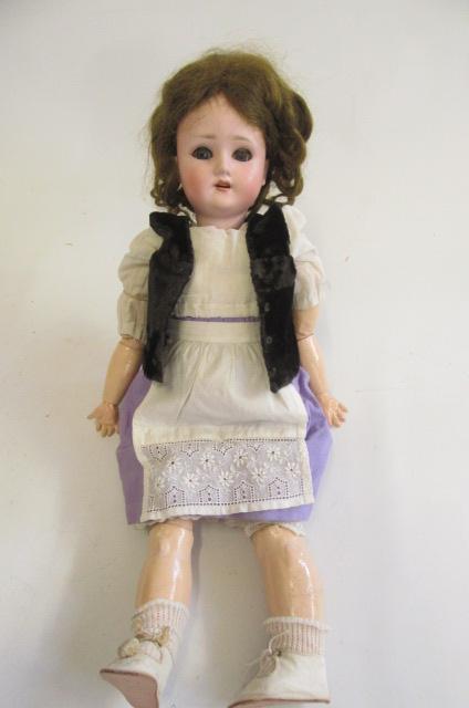 A Schoenau & Hoffmeister bisque socket head doll with blue glass sleeping eyes Image