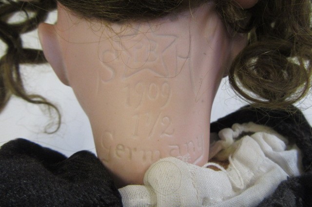 A Schoenau & Hoffmeister bisque socket head doll with blue glass sleeping eyes Image