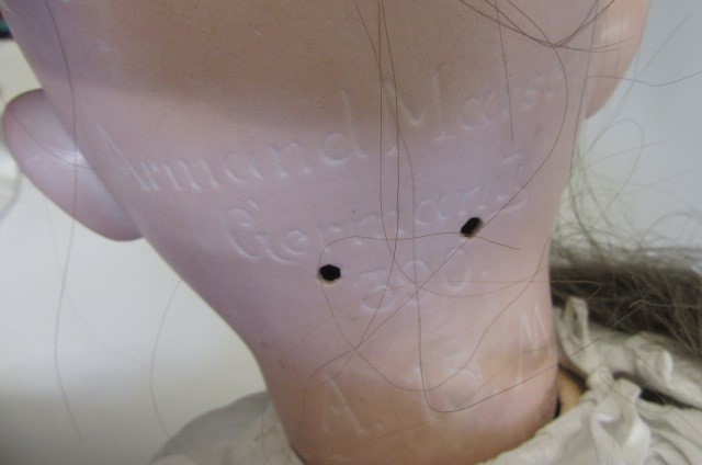 An Armand Marseille bisque socket doll with blue glass sleeping eyes Image