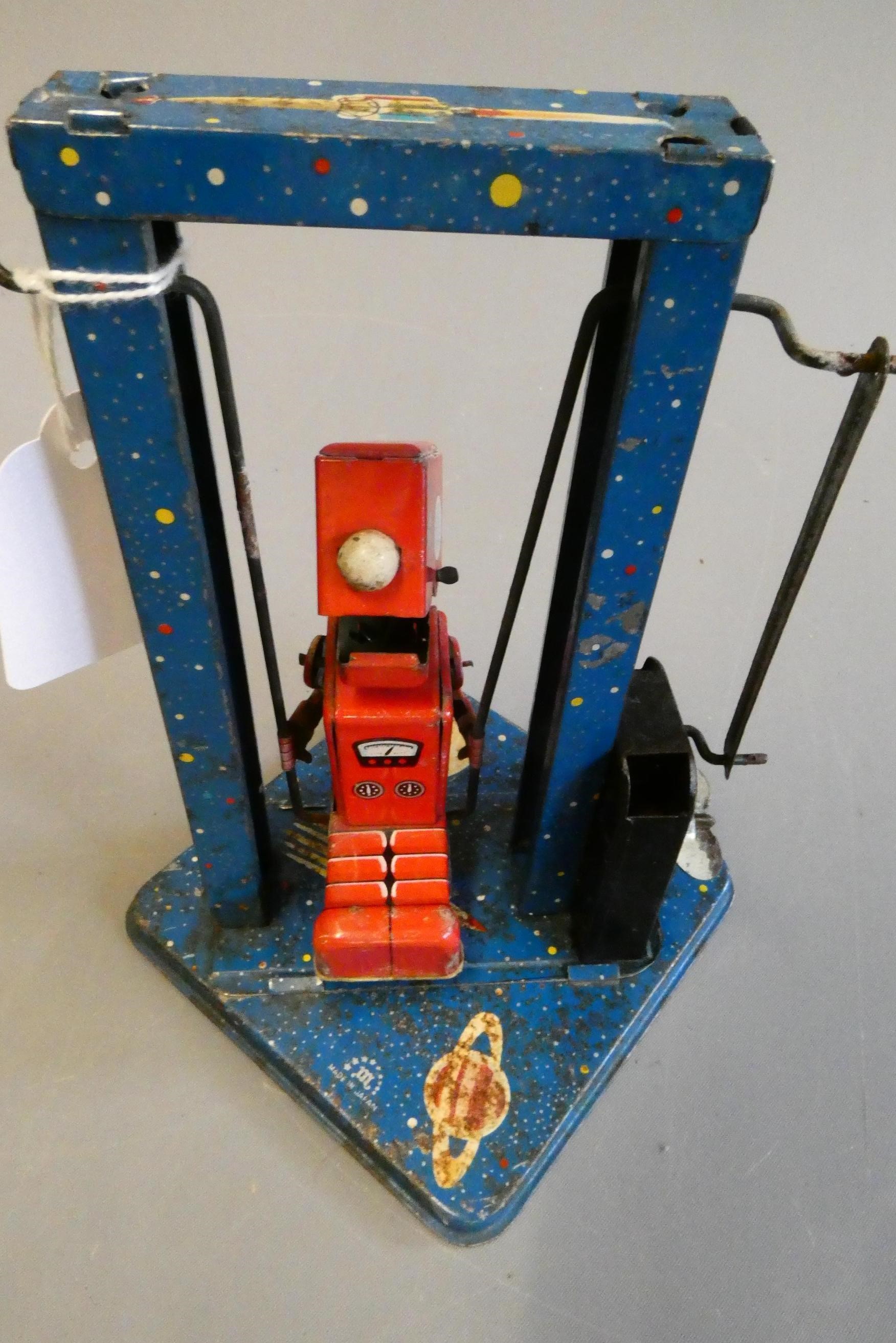Mikuni clockwork toy robot on a swing, some minor paint loss and rust on base, fair (Est. plus 24% Image