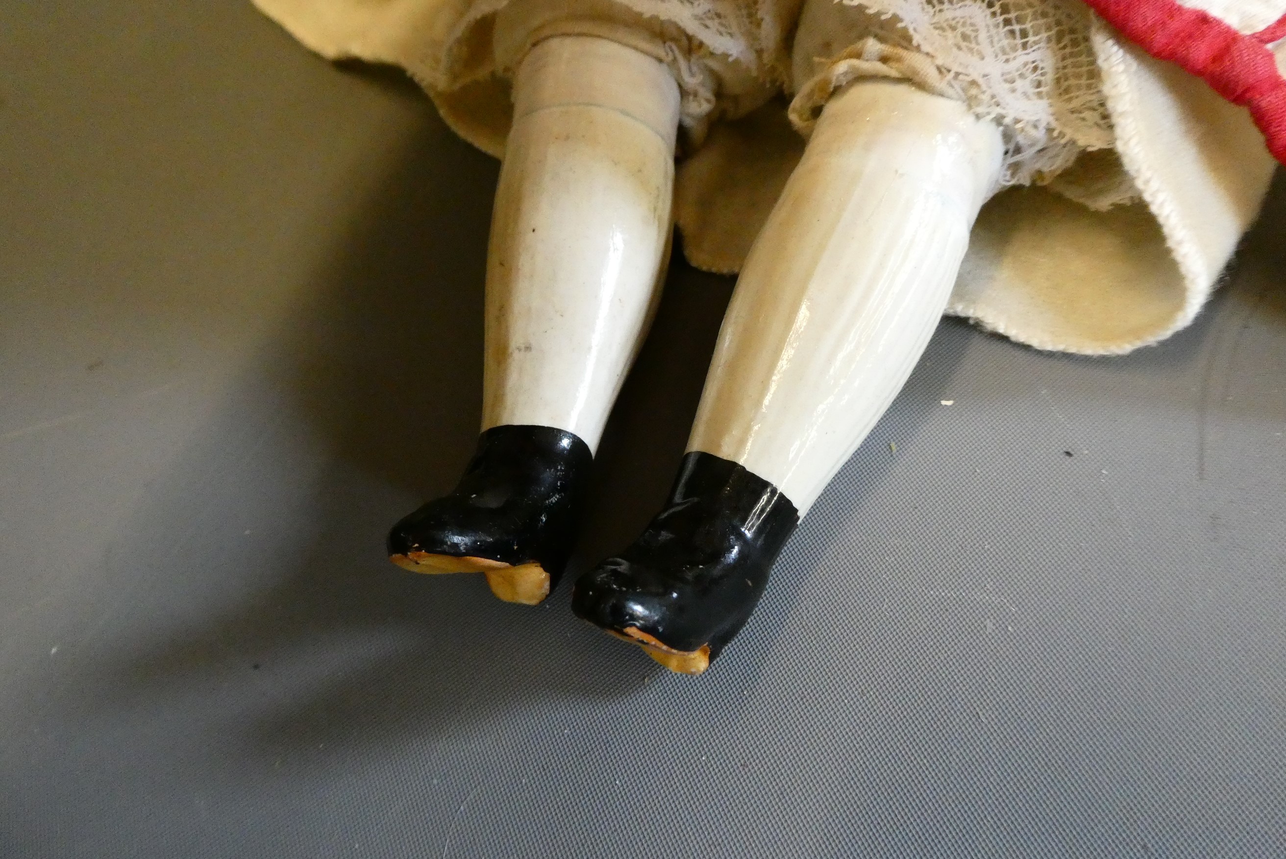 A Victorian china shoulder head doll, with painted features, moulded hair, fabric body, ceramic Image