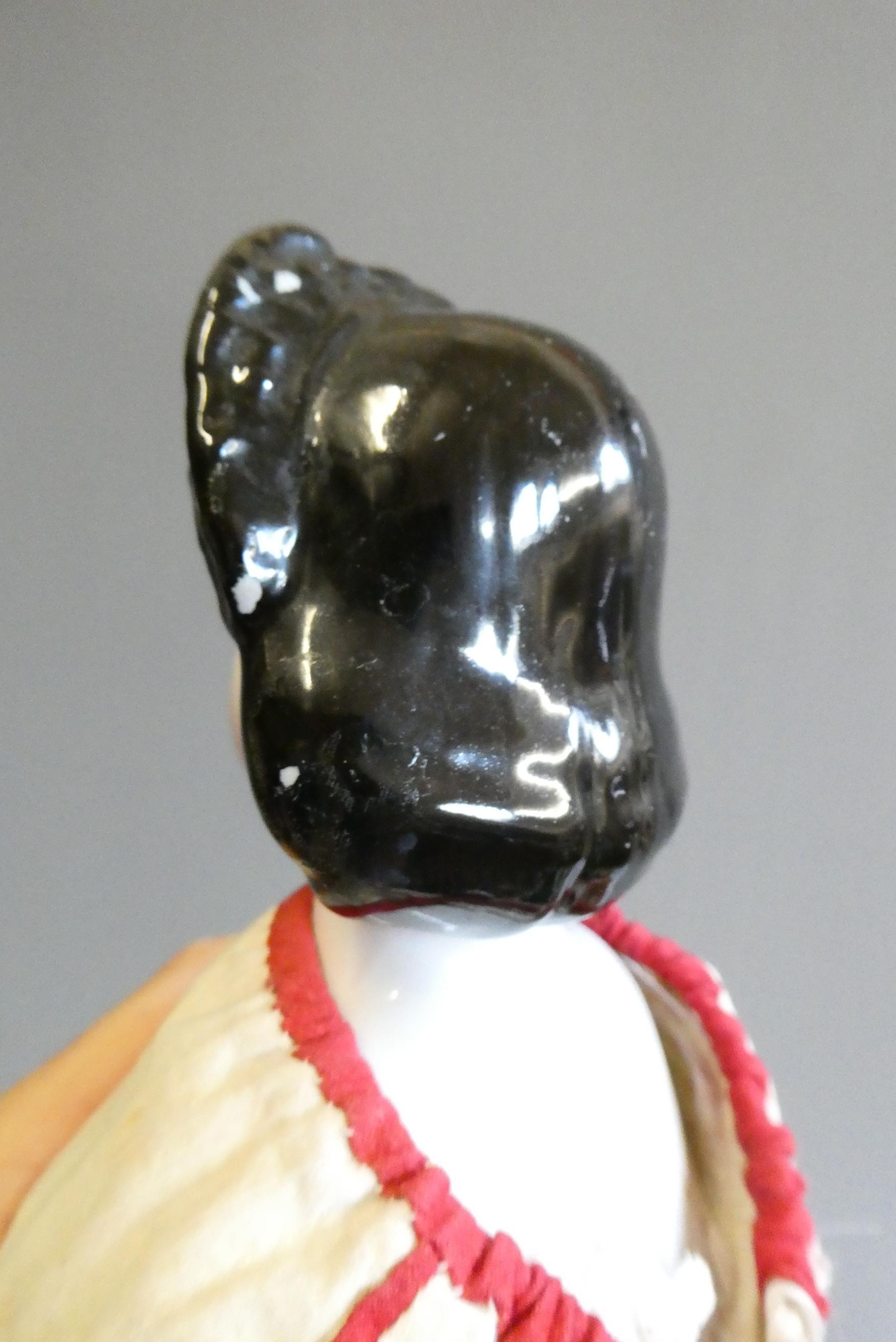 A Victorian china shoulder head doll, with painted features, moulded hair, fabric body, ceramic Image