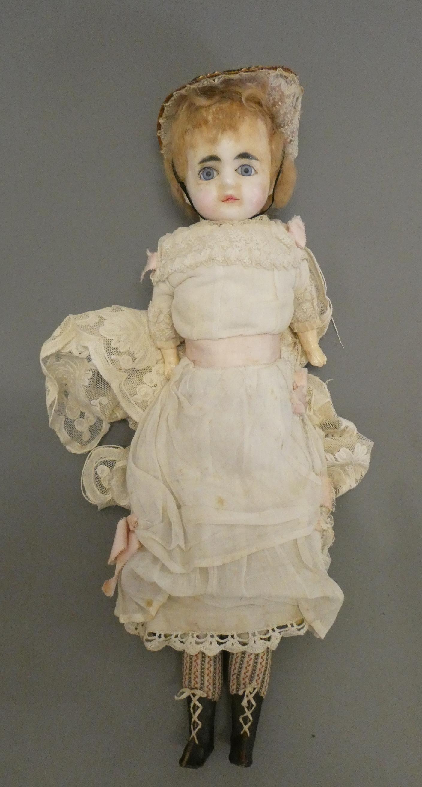 A Victorian wax shoulder head doll, with blue glass fixed eyes, closed mouth, composition lower Image