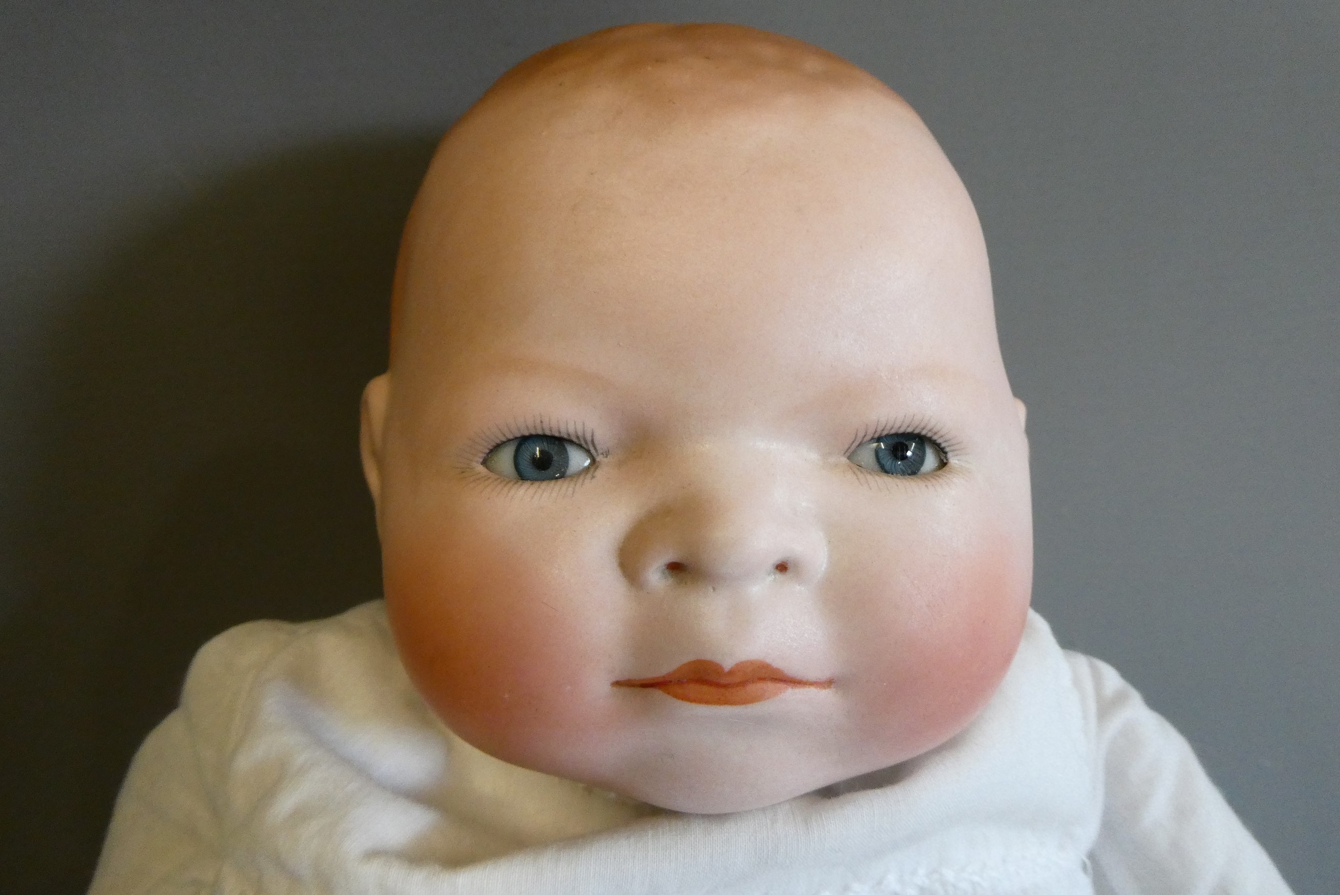 A Grace Putnam flange neck baby doll, with blue glass sleeping eyes, closed mouth, moulded and Image