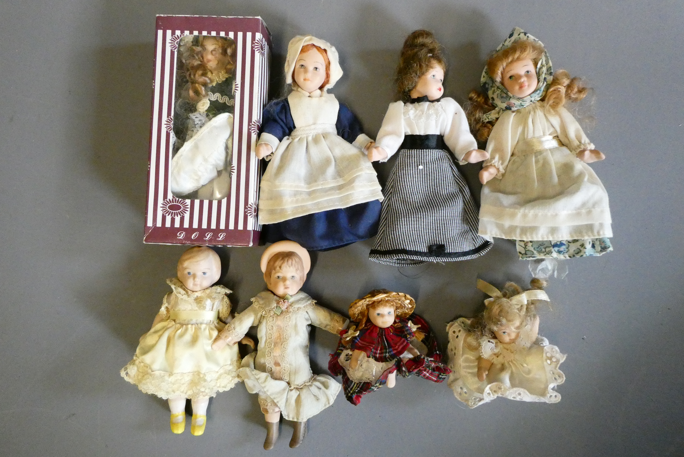 Eight doll's house dolls, seven of which all bisque, and one with fabric body, one boxed and all in Image