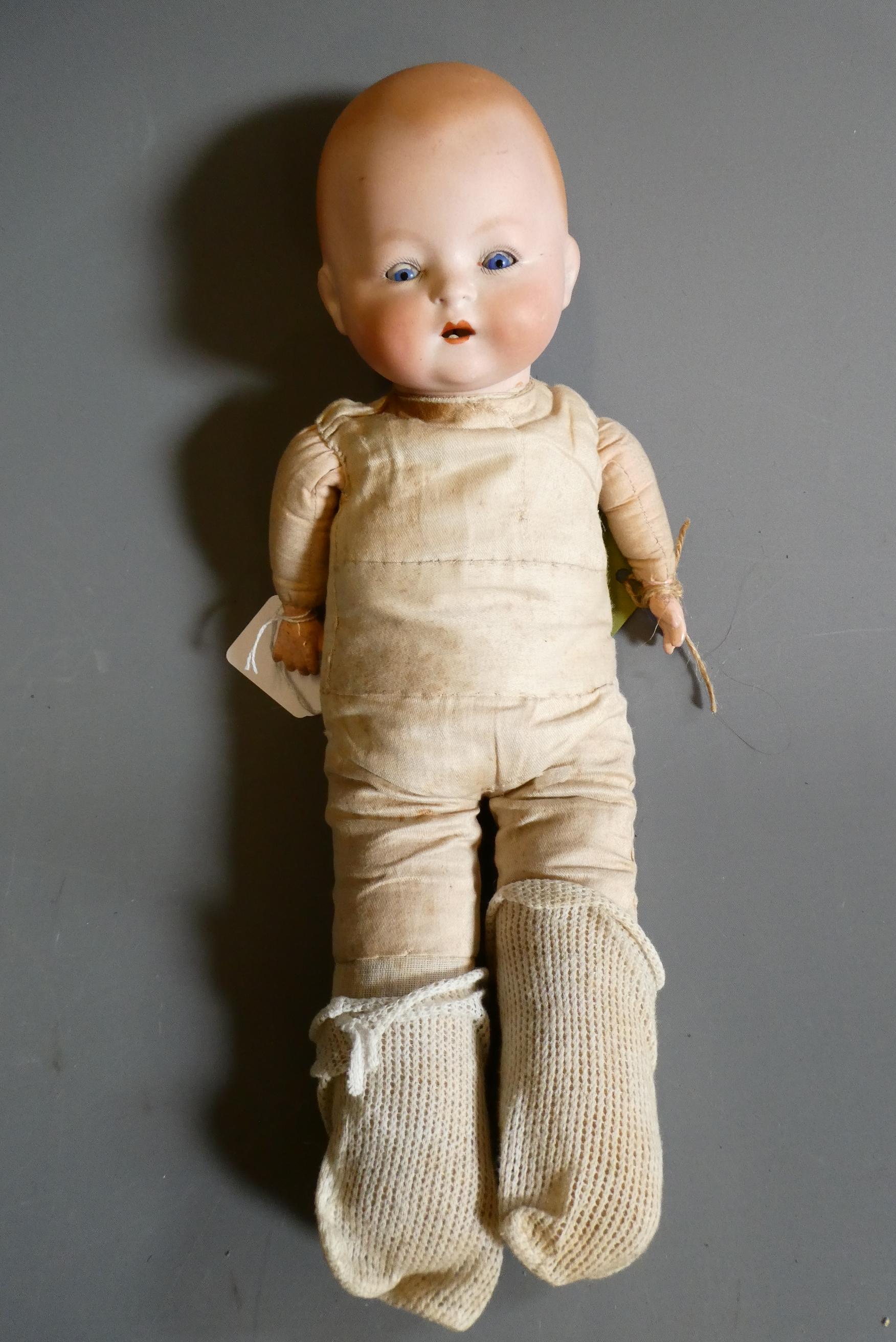 A Louis, Amberg & Son bisque flange neck baby doll, with fabric body and composition hands, numbered Image