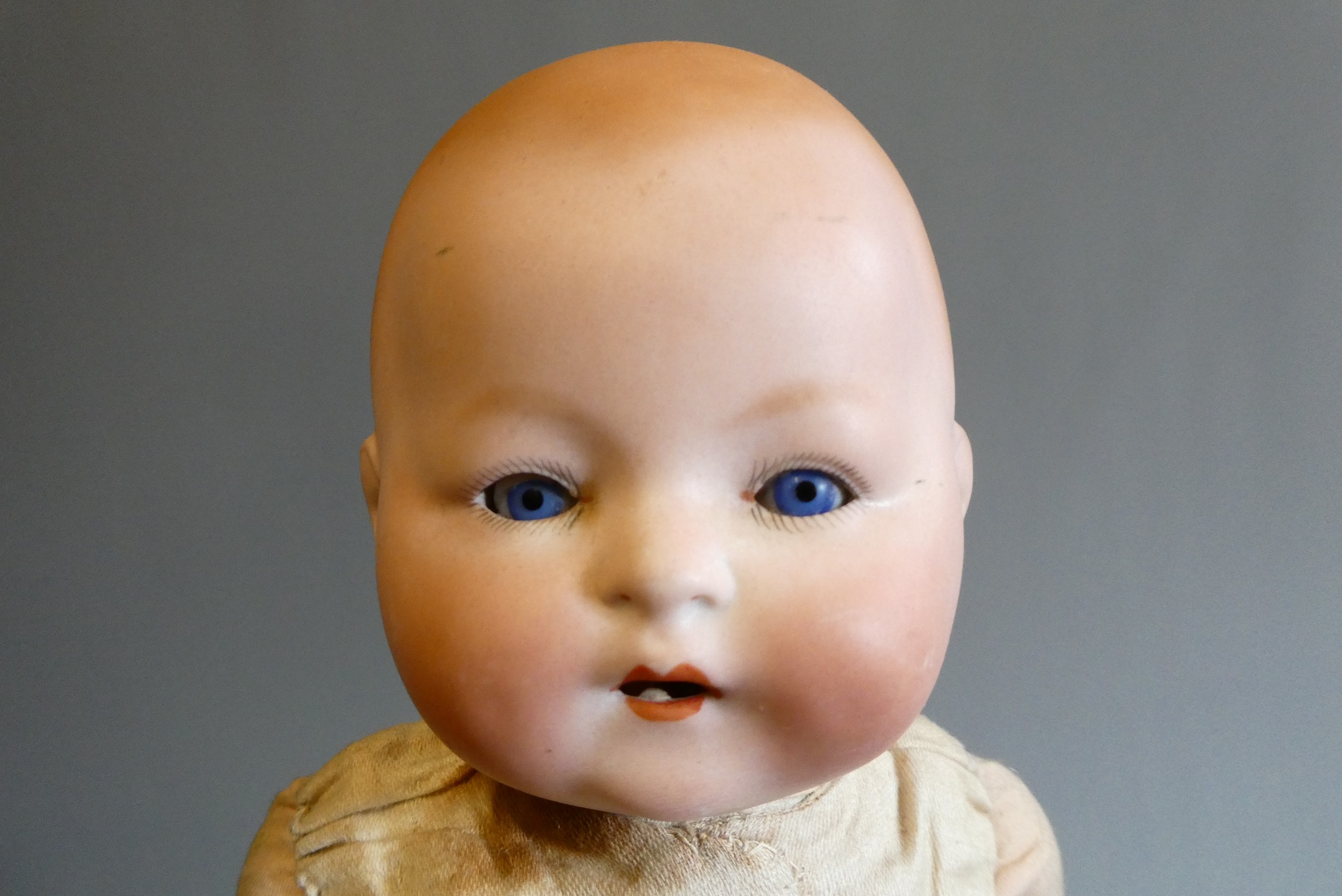 A Louis, Amberg & Son bisque flange neck baby doll, with fabric body and composition hands, numbered Image