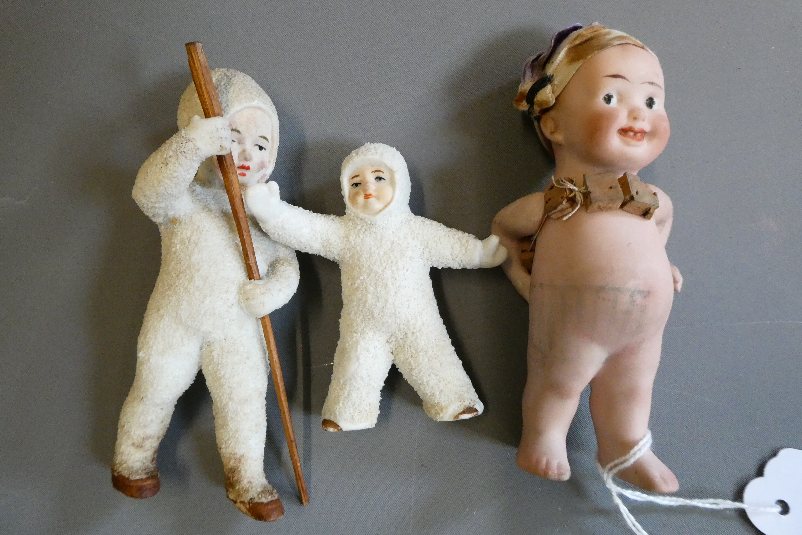 Three all bisque miniature dolls, comprising a 4 1/2" standing character doll, with painted features Image
