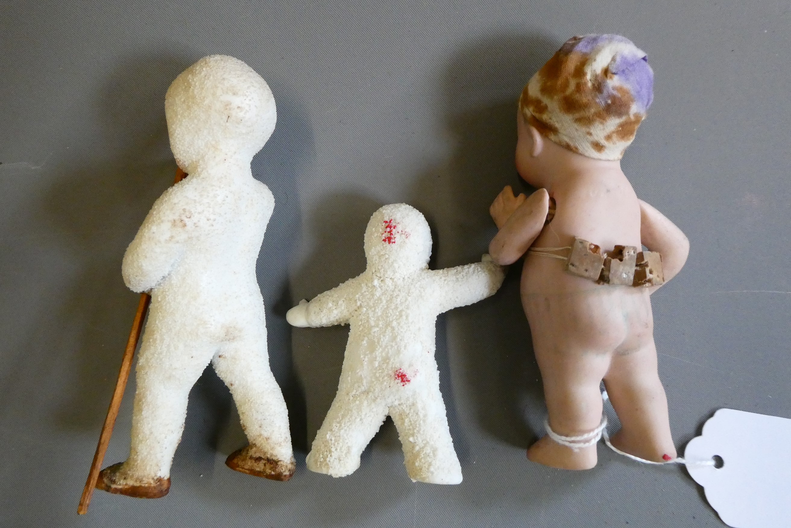 Three all bisque miniature dolls, comprising a 4 1/2" standing character doll, with painted features Image