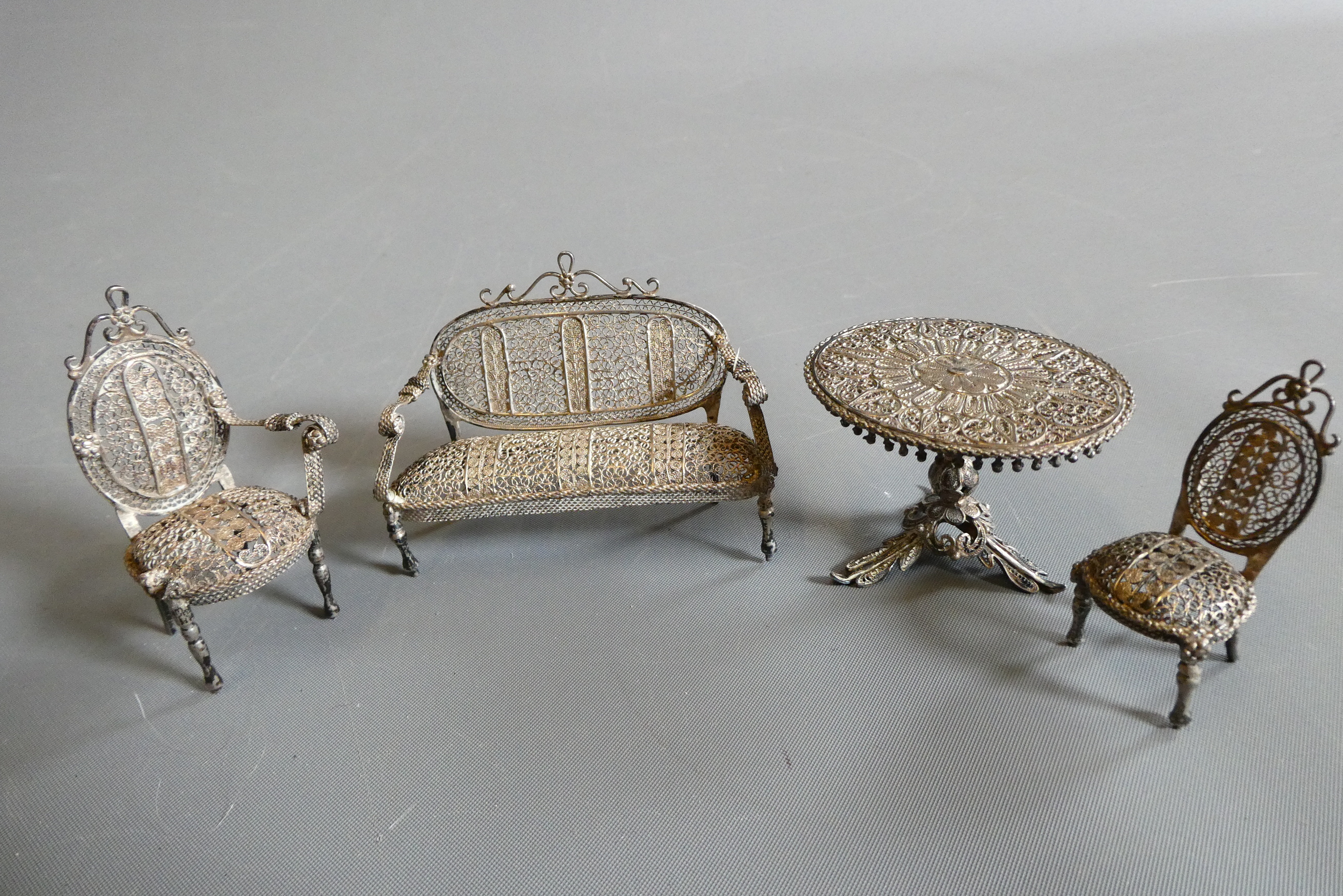 Antique filigree white metal doll's house furniture comprising two chairs, a settee and a pedestal Image