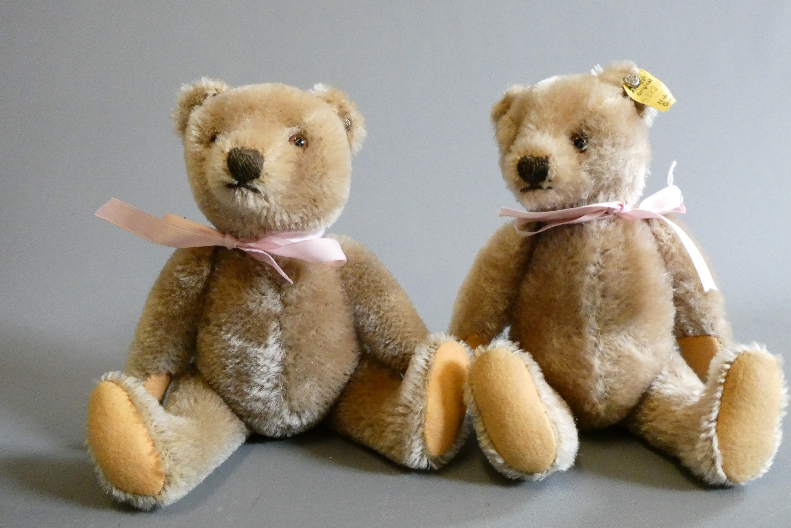 A pair of 1950s Steiff teddy bears, both with amber glass eyes, sewn noses, felt pads and ears with Image