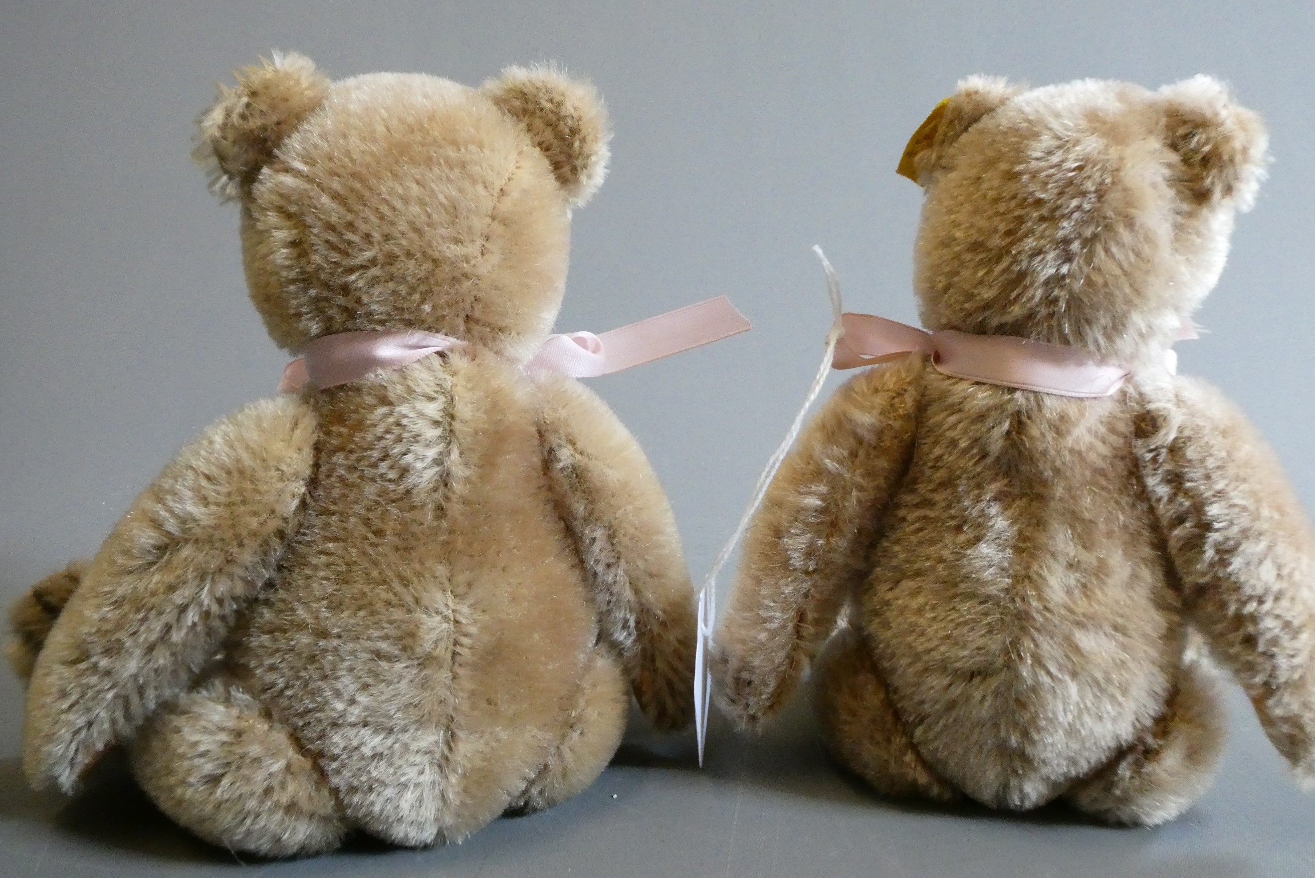 A pair of 1950s Steiff teddy bears, both with amber glass eyes, sewn noses, felt pads and ears with Image