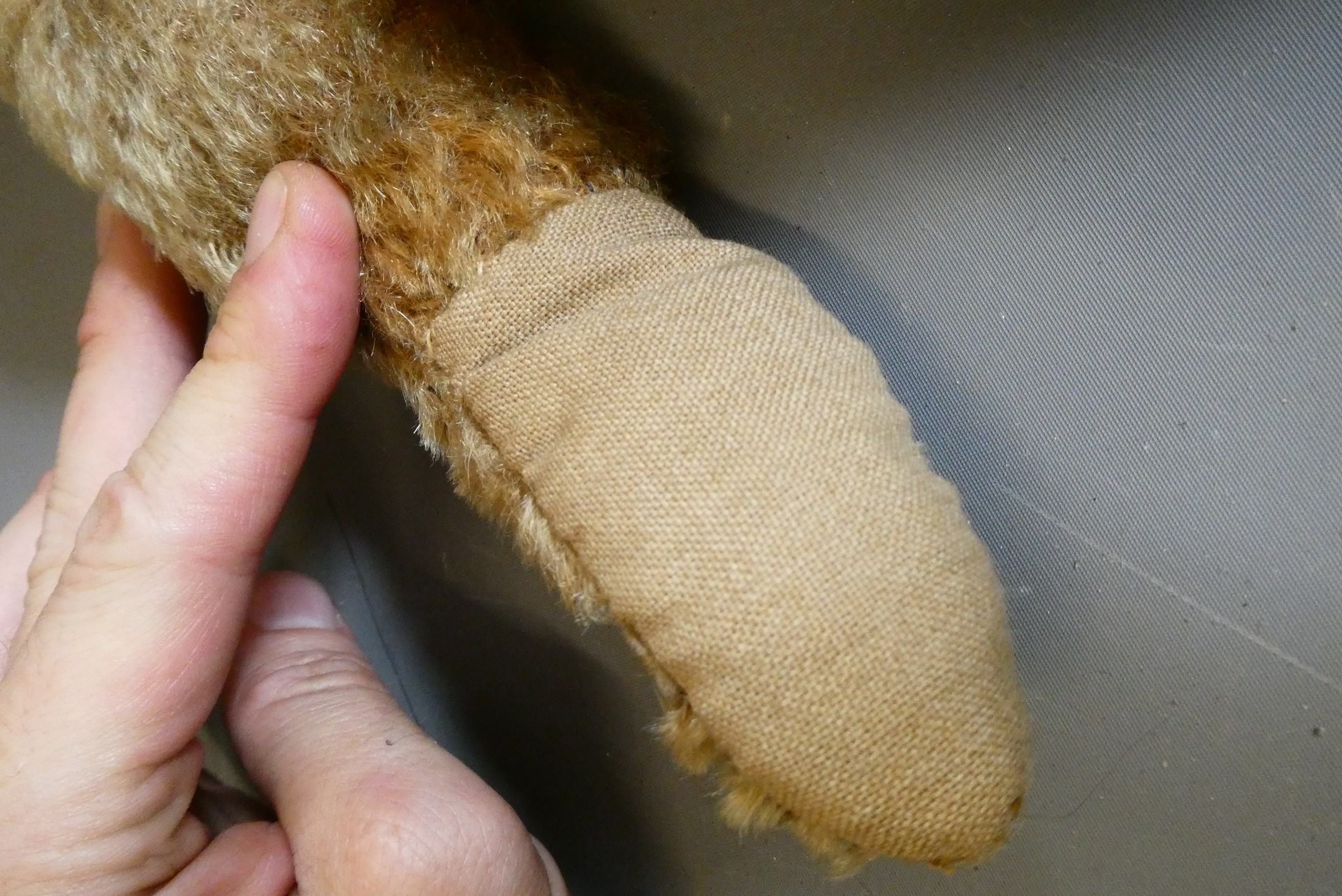 A pre-war shoe button eye teddy bear, with sewn nose, brown plush, bell to neck, jointed shoulders Image