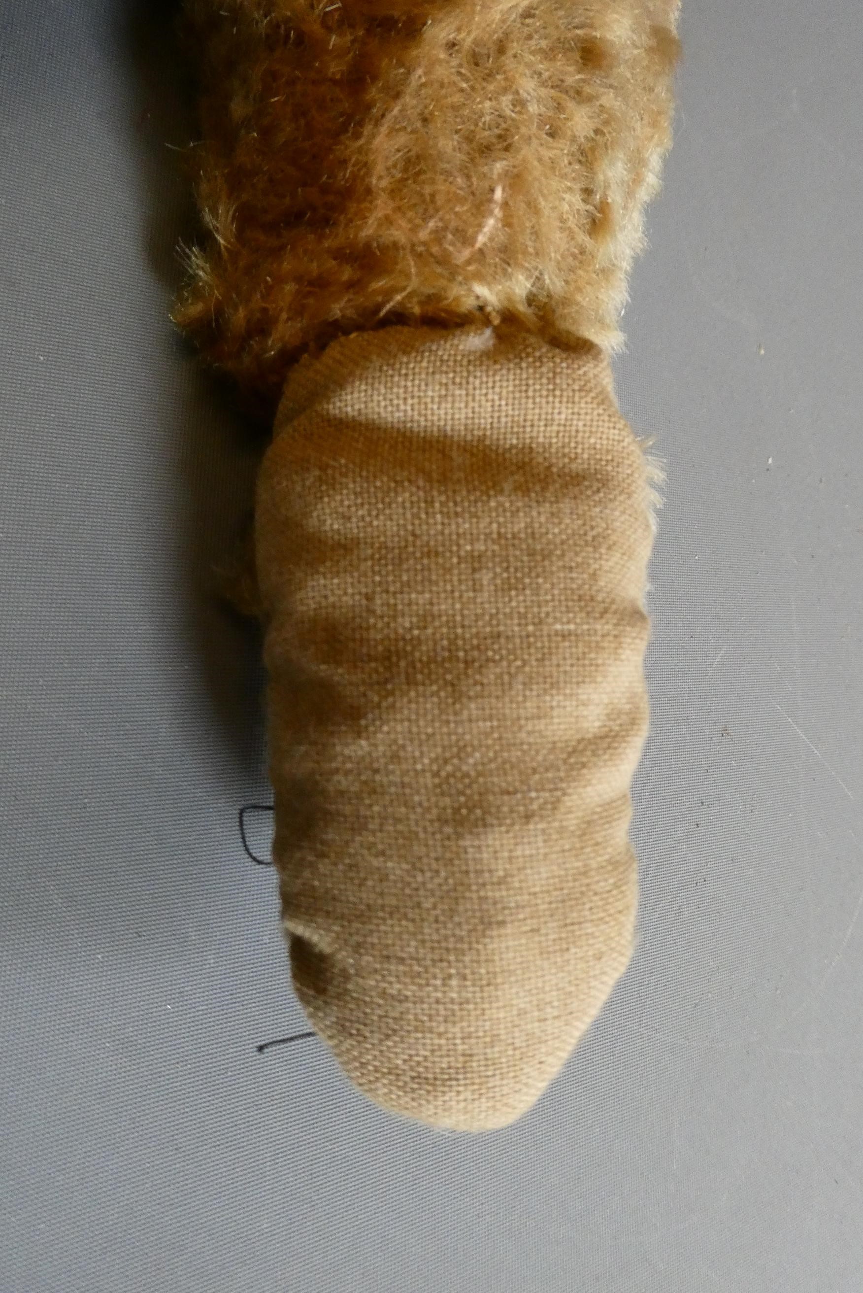 A pre-war shoe button eye teddy bear, with sewn nose, brown plush, bell to neck, jointed shoulders Image