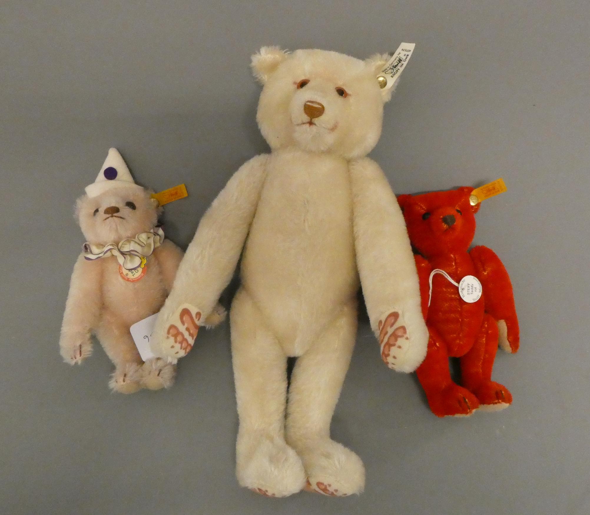 Three Steiff teddy bears, comprising a 12 1/2" white bear, a 6 3/4" red bear and a 7 3/4" teddy Image