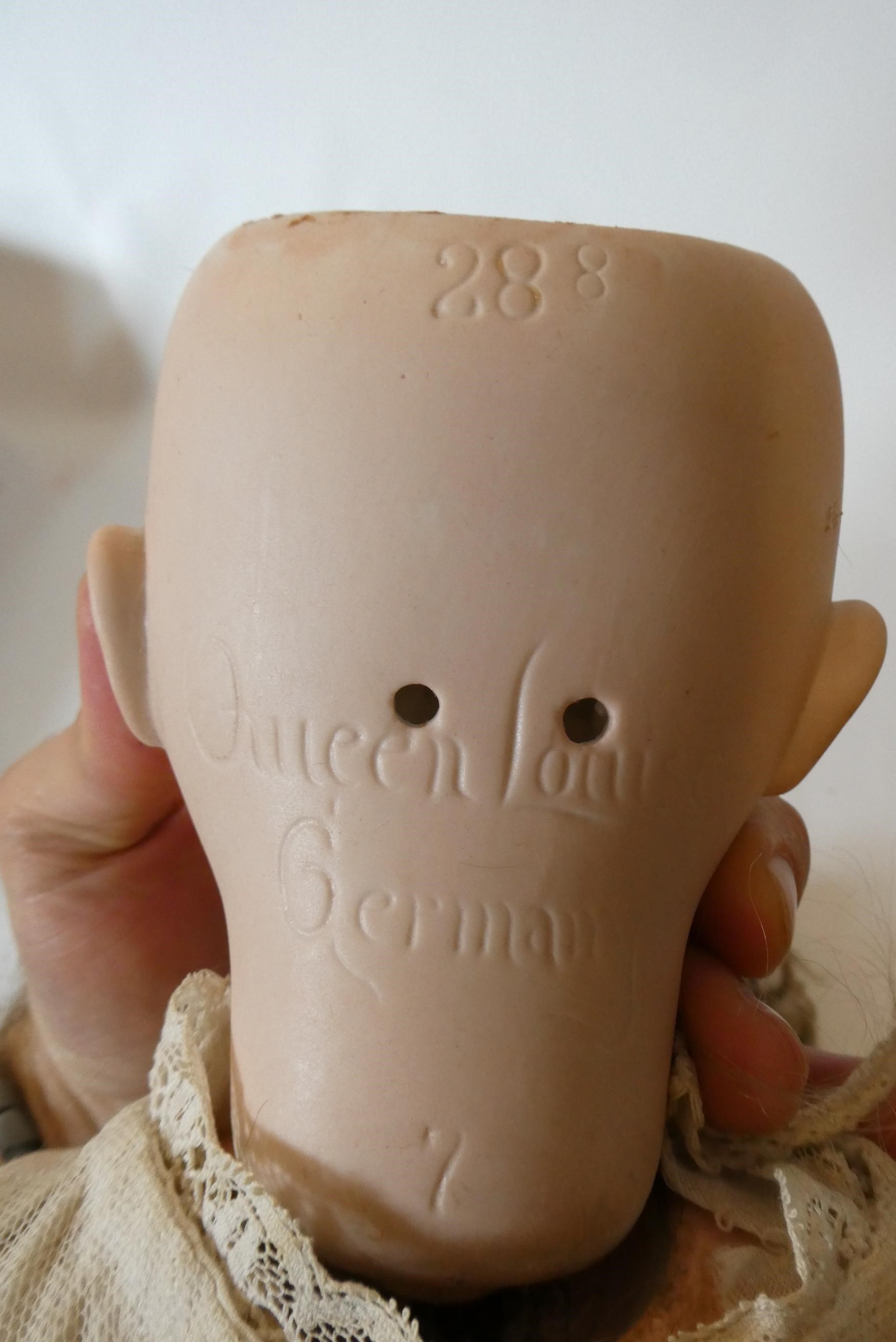 A Queen Louise bisque socket head doll with blue glass sleeping eyes Image