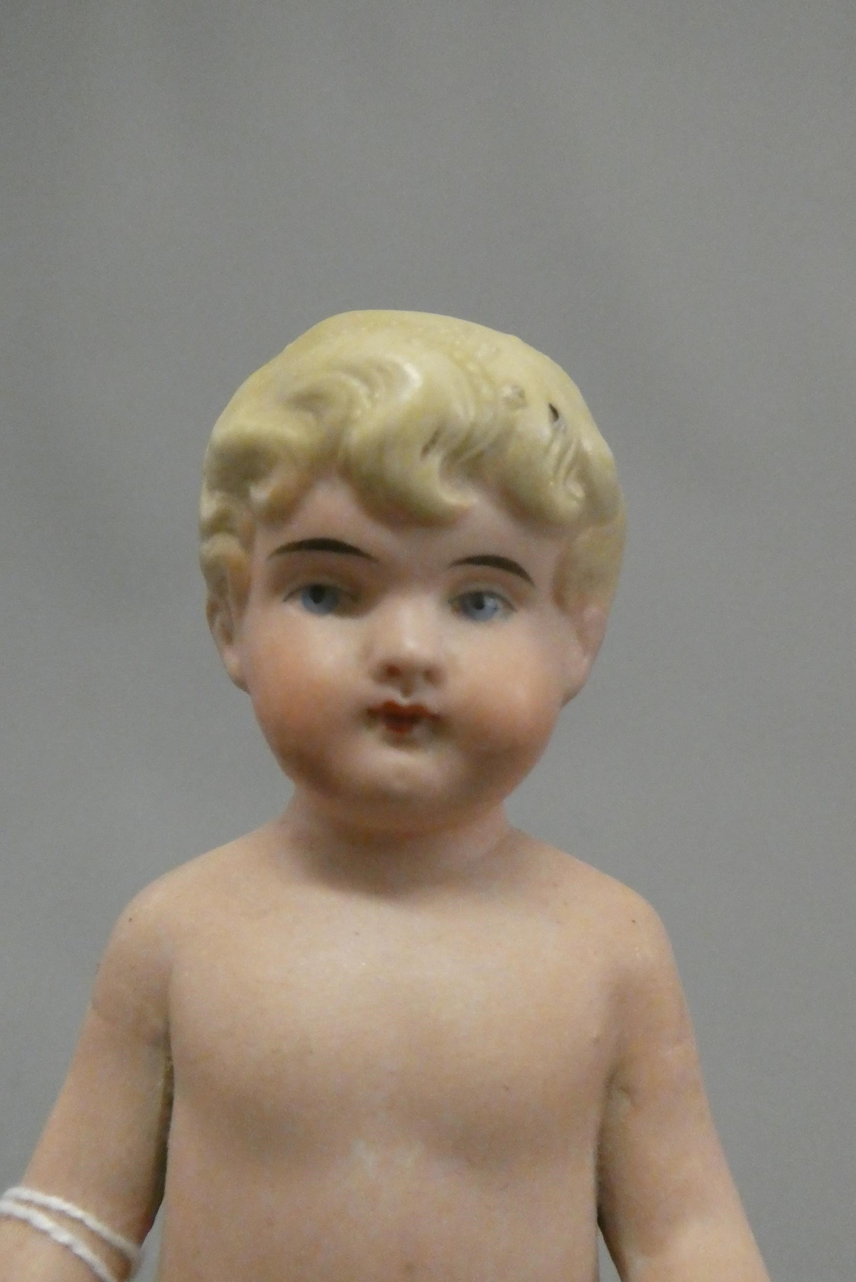 An all bisque frozen Charlotte doll, with blond moulded hair, painted features and bent arms, 5 3/4" Image