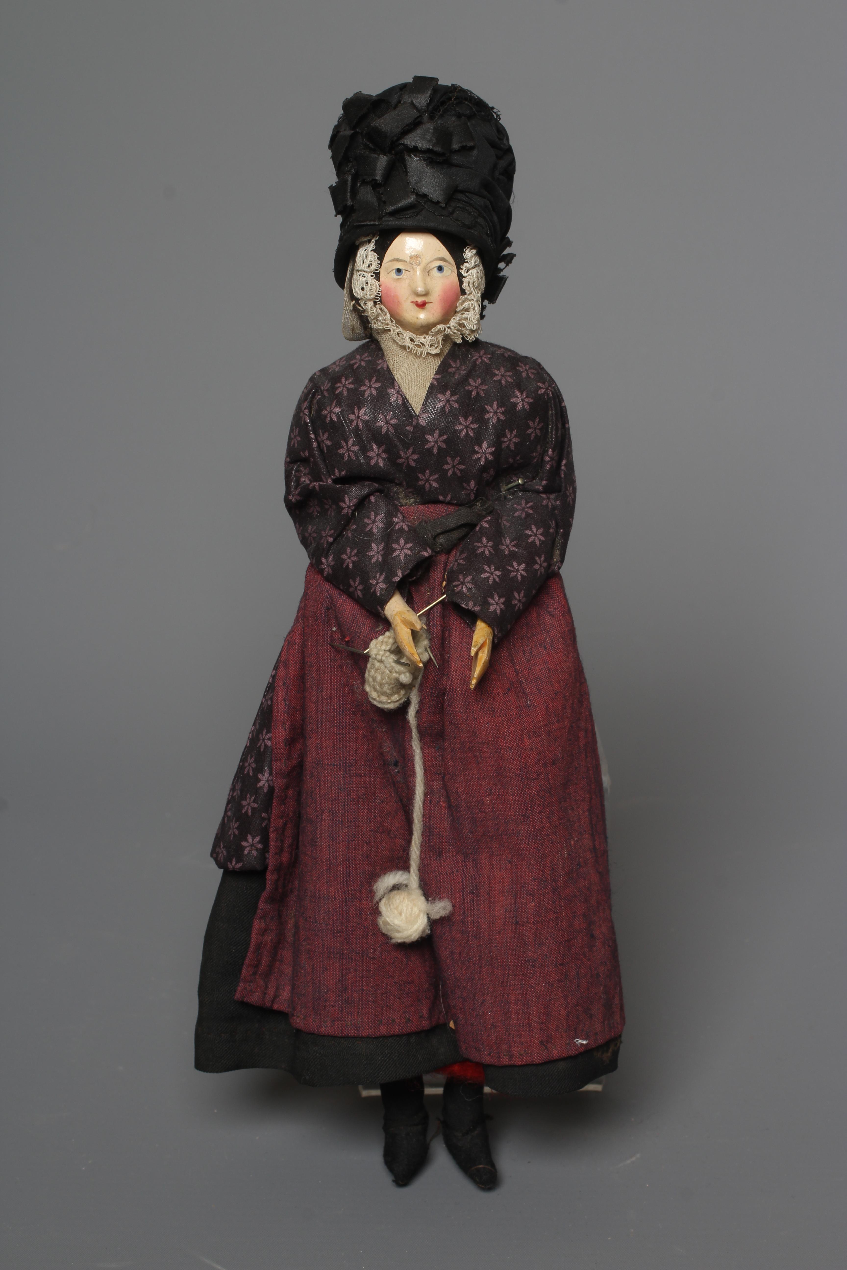 A rare Victorian wooden doll, with carved and painted face, fabric body, wooden lower limbs and Image