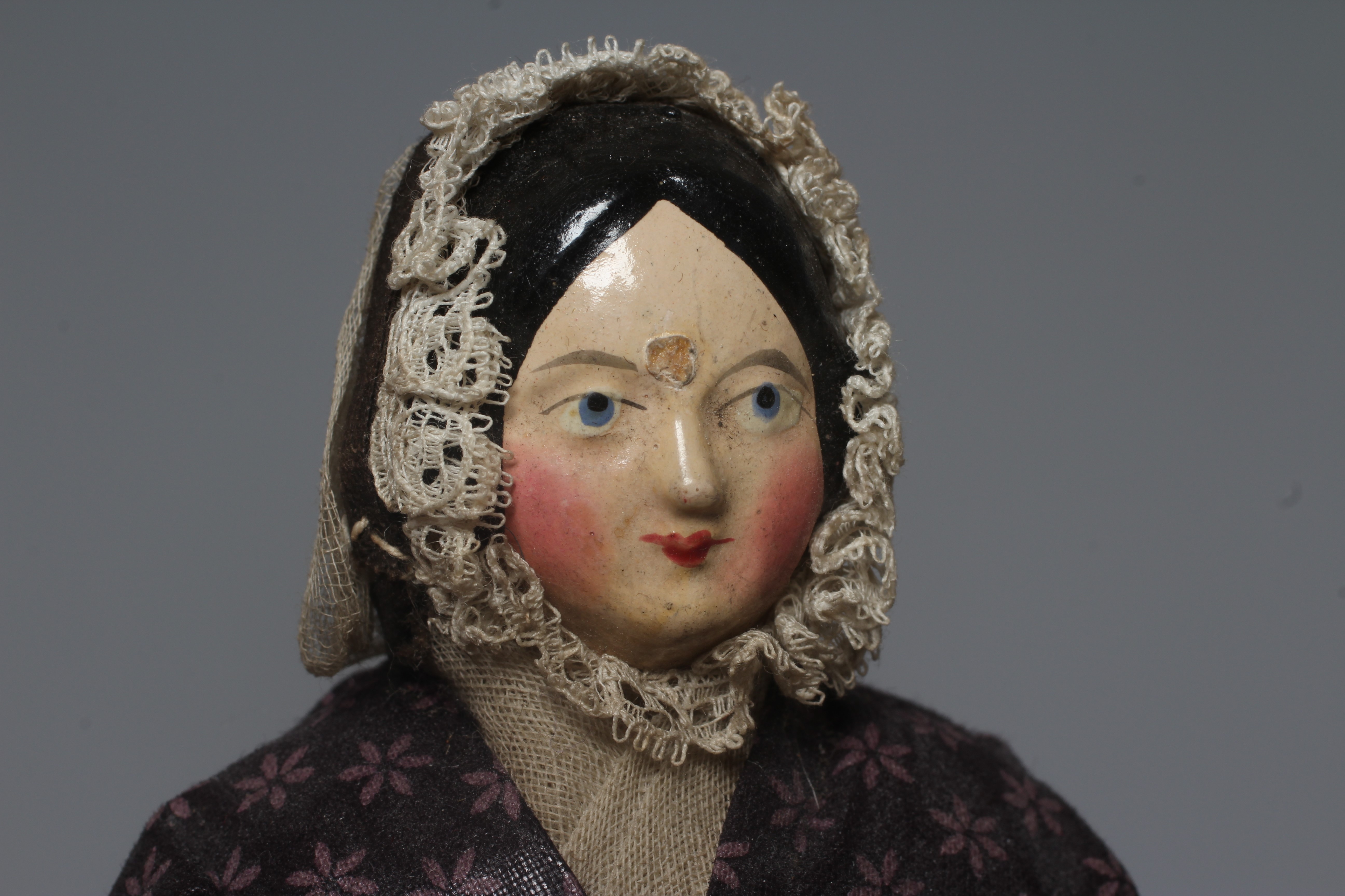 A rare Victorian wooden doll, with carved and painted face, fabric body, wooden lower limbs and Image