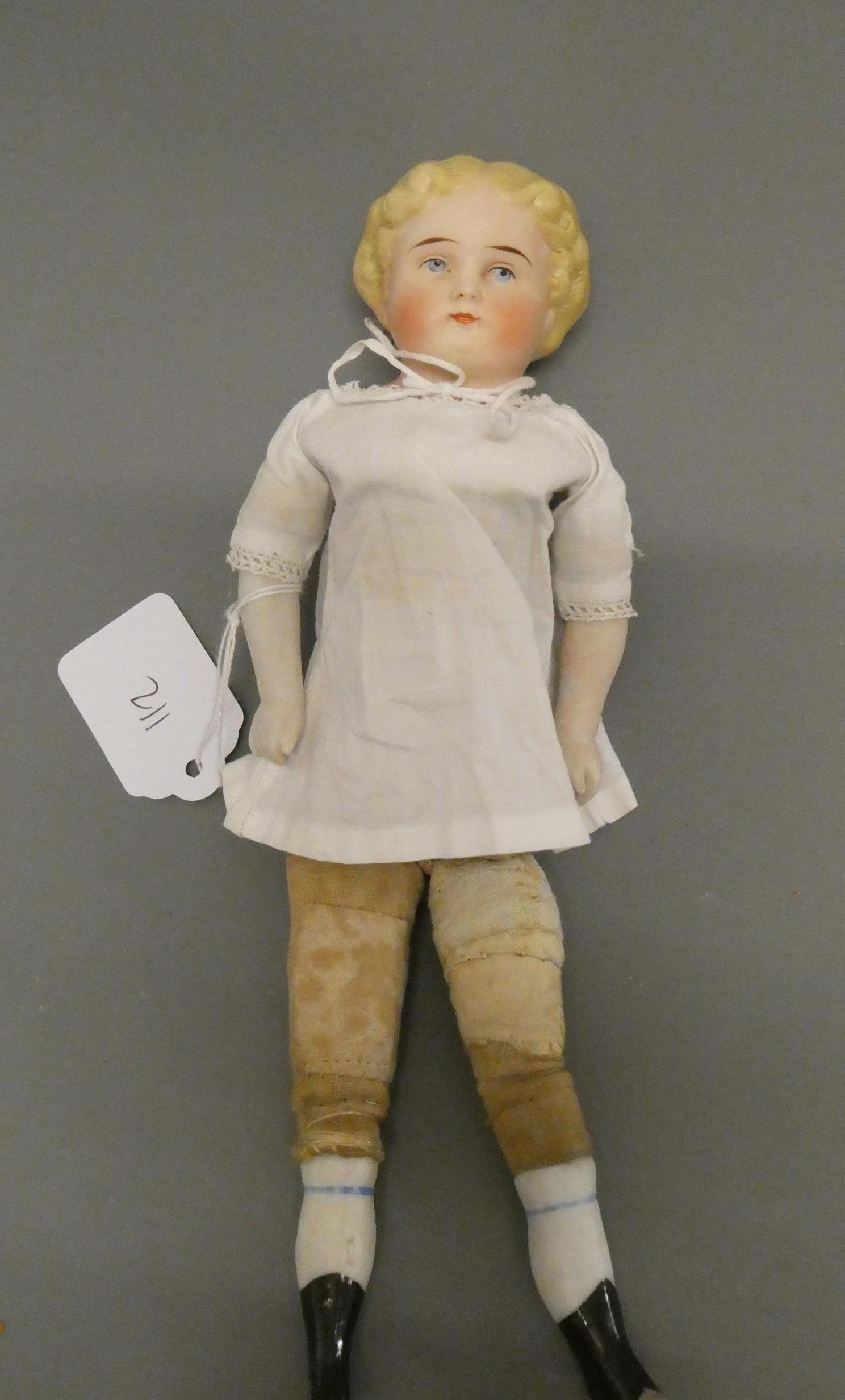 An antique bisque shoulder head doll, with moulded hair, painted features, bisque lower limbs and Image
