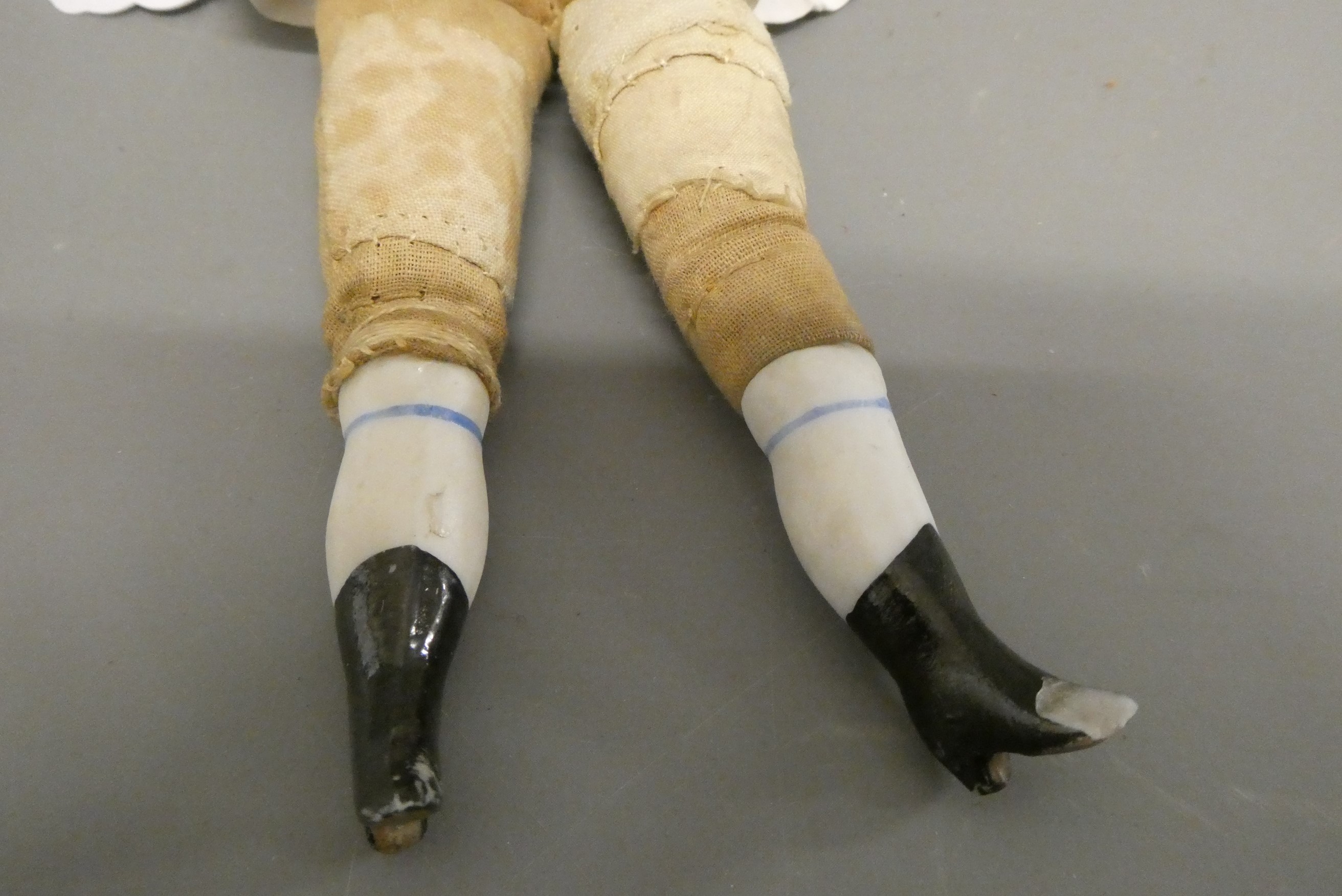 An antique bisque shoulder head doll, with moulded hair, painted features, bisque lower limbs and Image