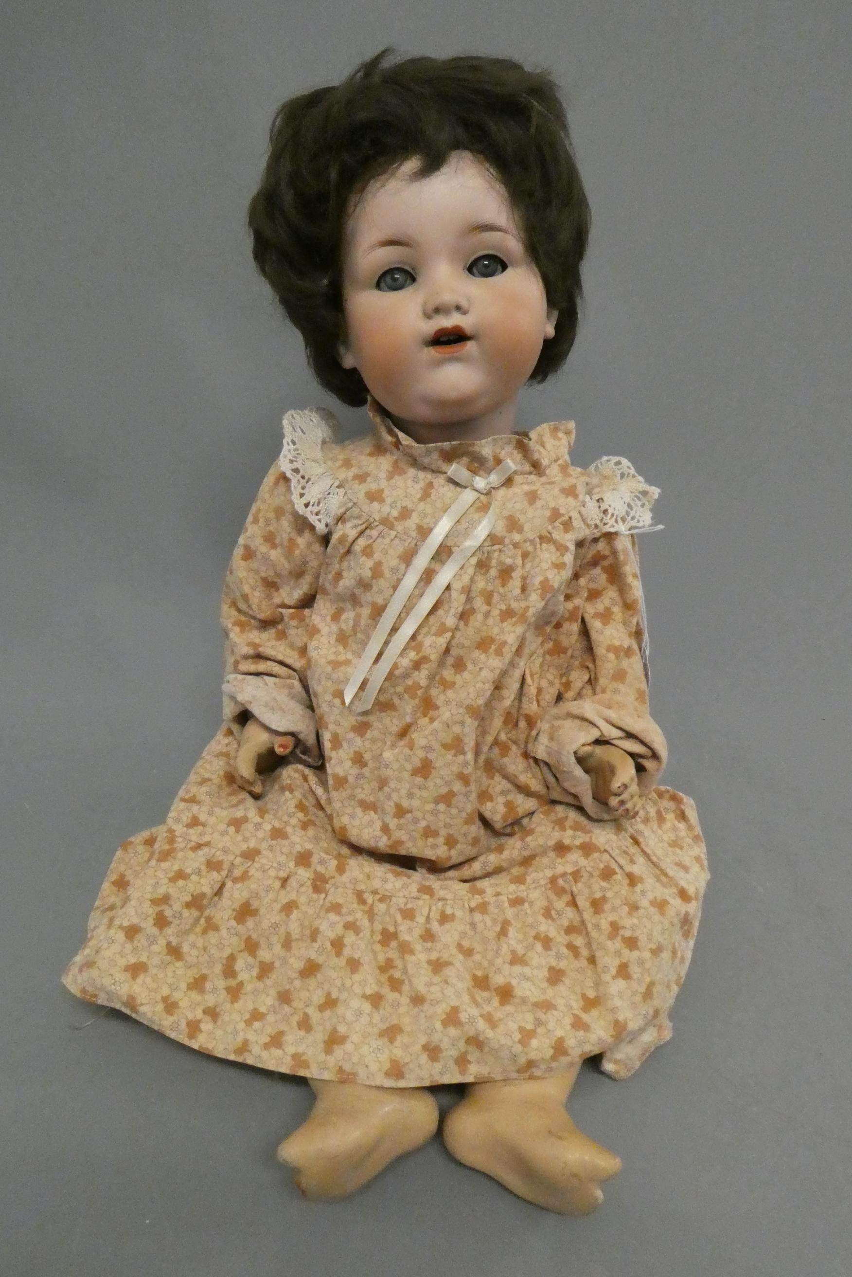 An Armand Marseille bisque socket head doll, with blue glass sleeping eyes, open mouth, teeth, bent Image