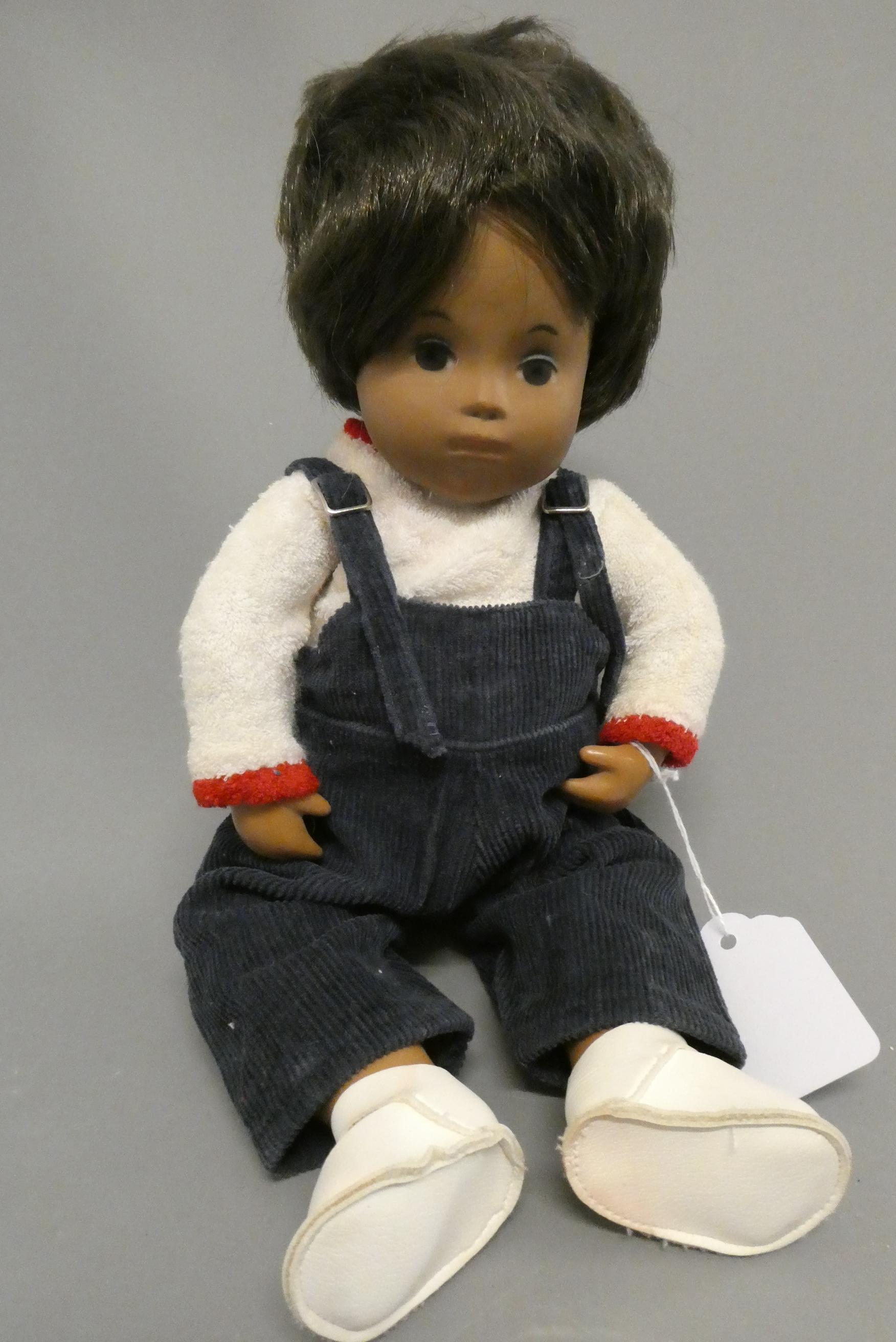 A Sasha toddler, with brown hair and original outfit including dungarees and shoes, 11" long (Est. Image