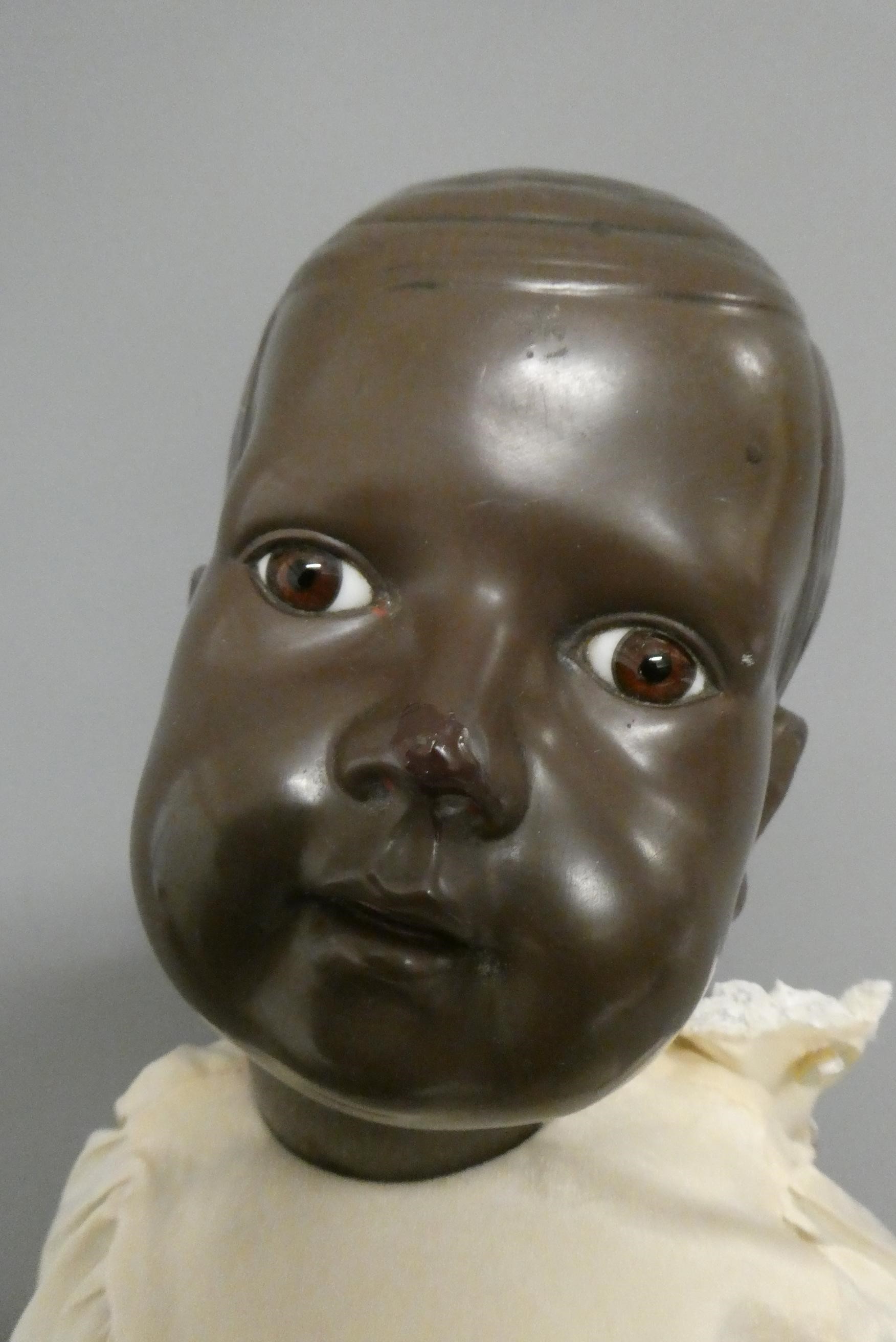 A Rheinische Gummi celluloid baby boy doll, with brown glass fixed eyes, moulded hair, closed mouth Image