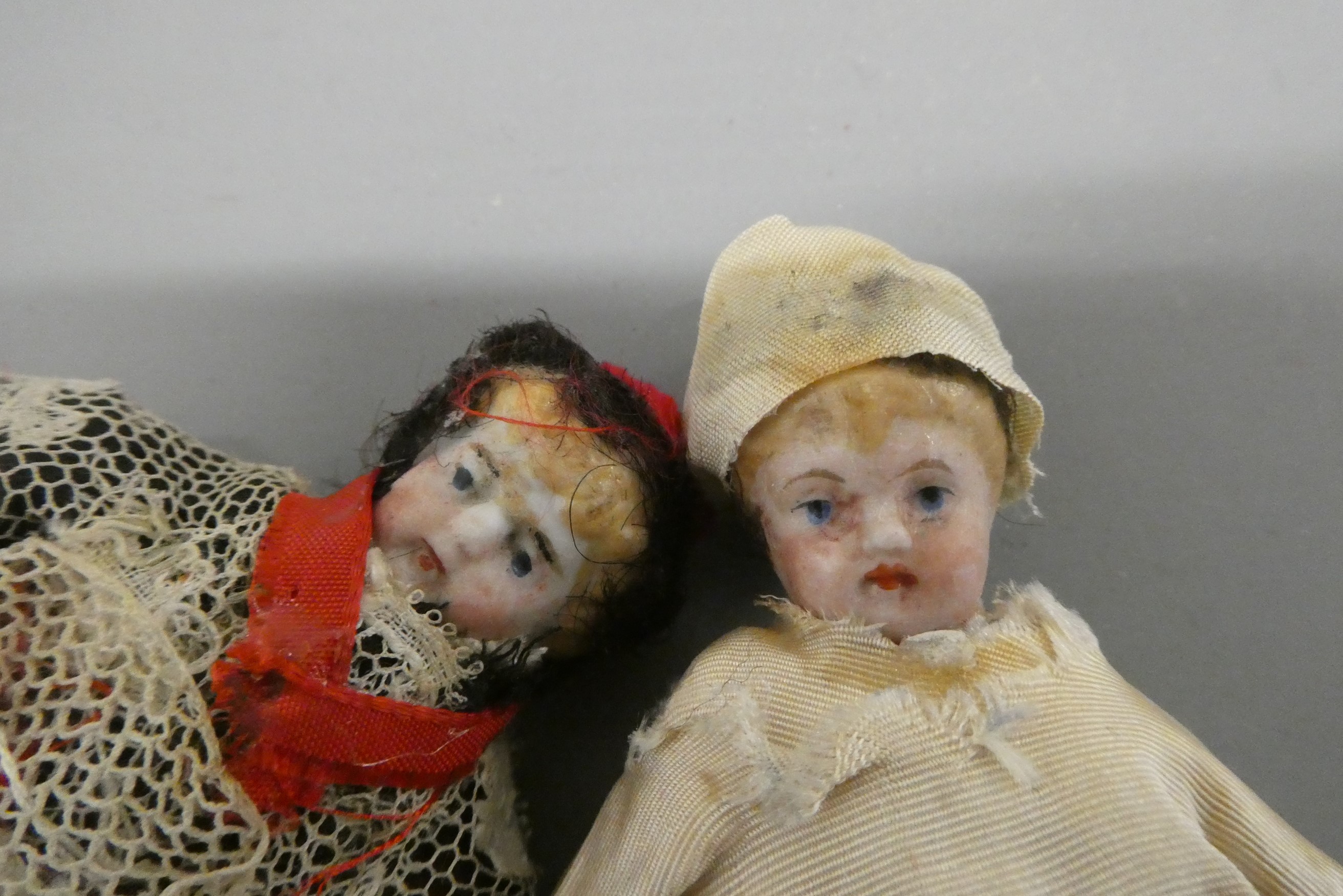 Two bisque shoulder head doll's house dolls, both with moulded hair, painted features and bisque Image
