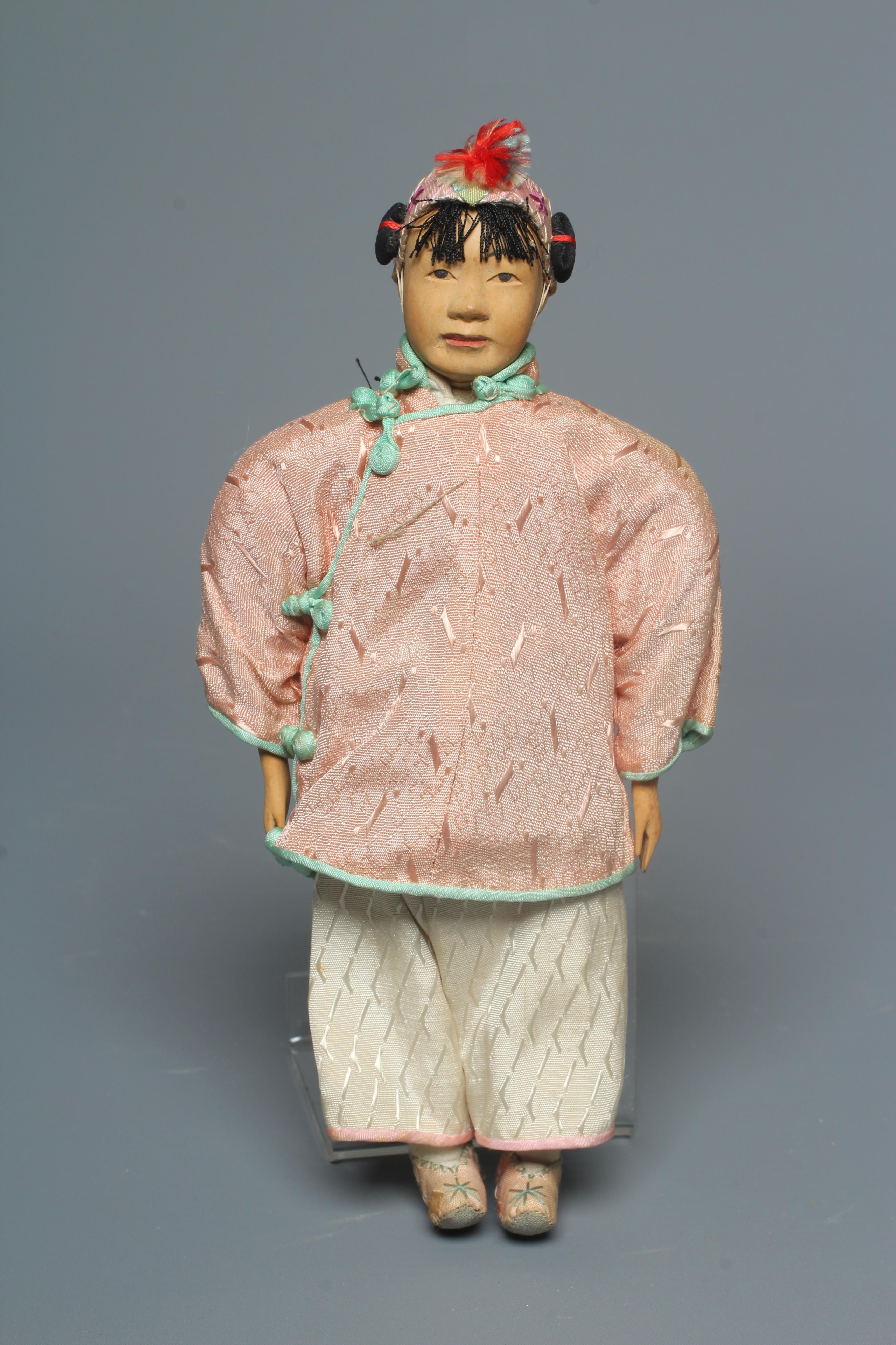 A Chinese "Door of Hope" girl doll, with carved and painted features and original outfit, 8" long Image