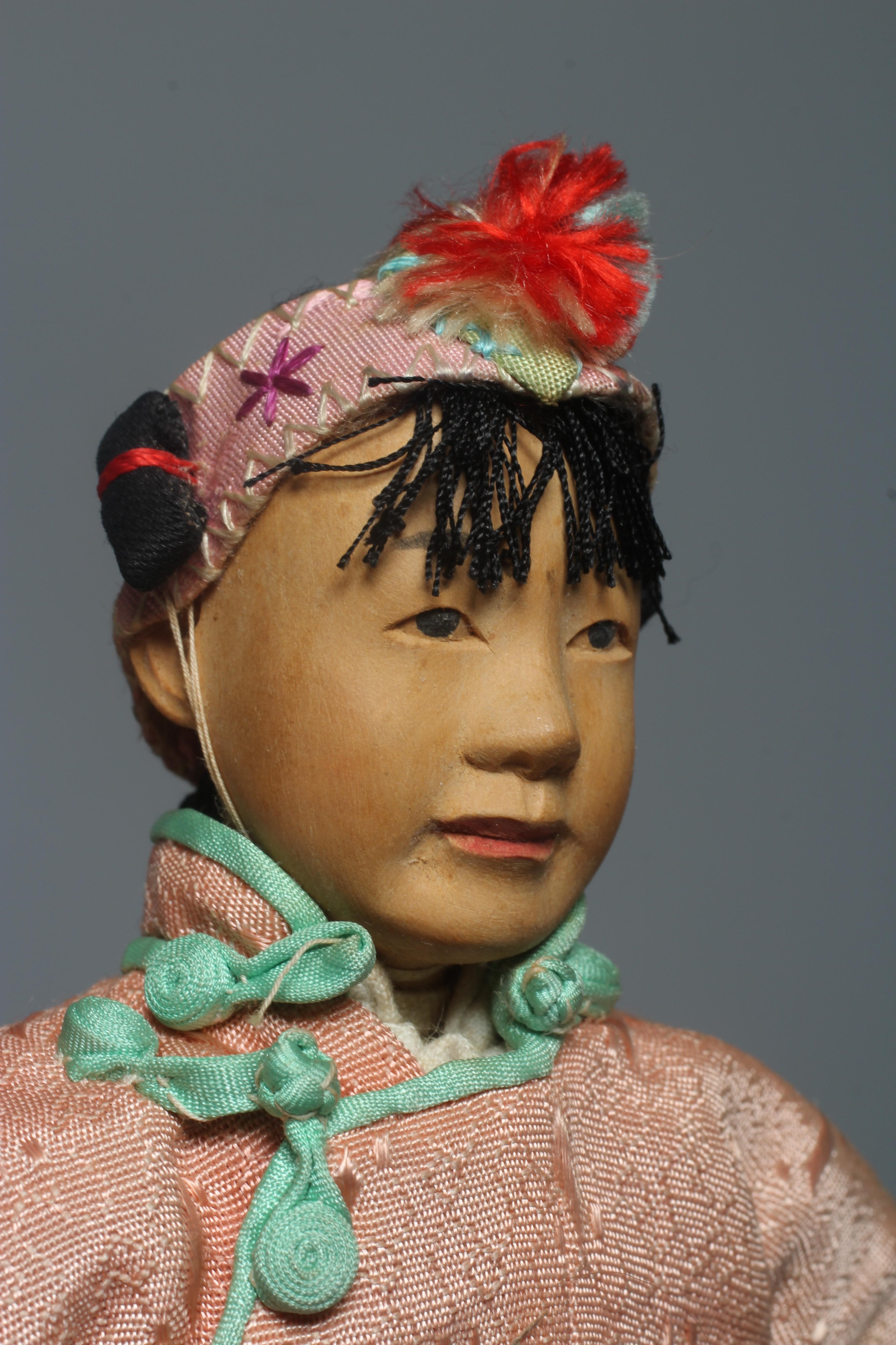 A Chinese "Door of Hope" girl doll, with carved and painted features and original outfit, 8" long Image