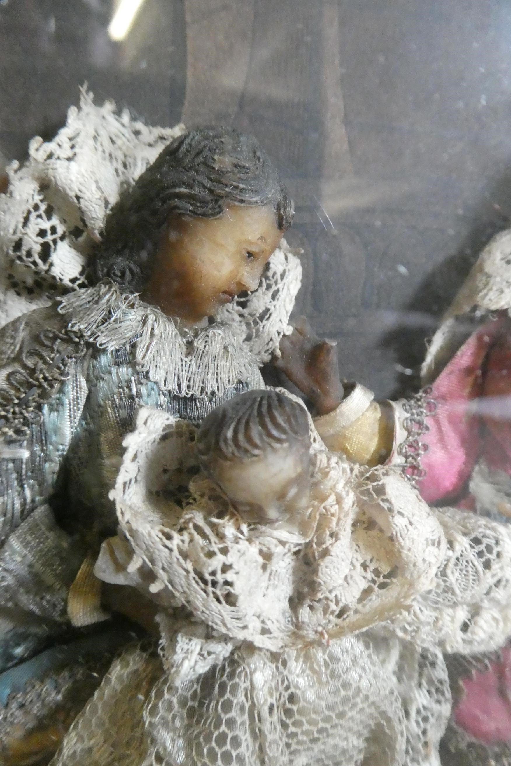 A wax nativity diorama, the figures with moulded and painted wax heads and hands, and silk and lace Image
