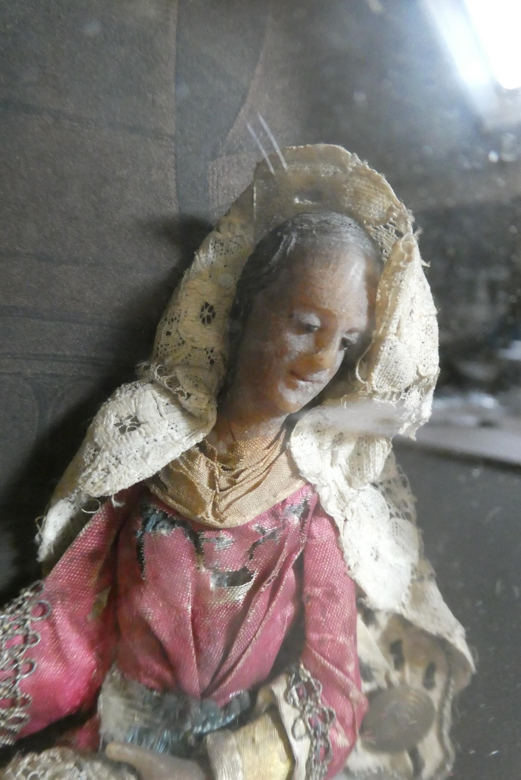 A wax nativity diorama, the figures with moulded and painted wax heads and hands, and silk and lace Image
