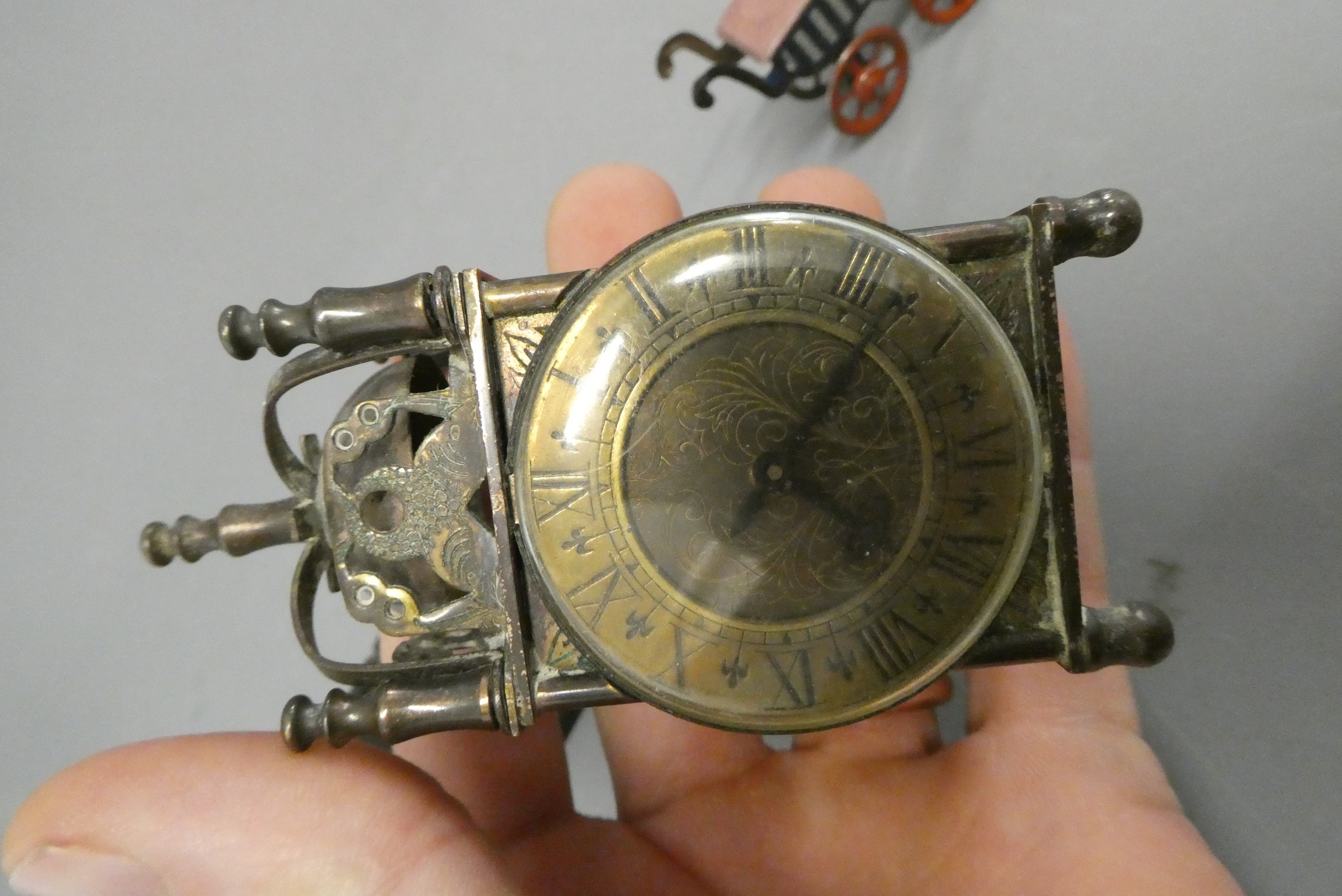 Three doll's house items, comprising a 3 3/4" British made brass lantern clock, a 2 3/8" tinplate Image