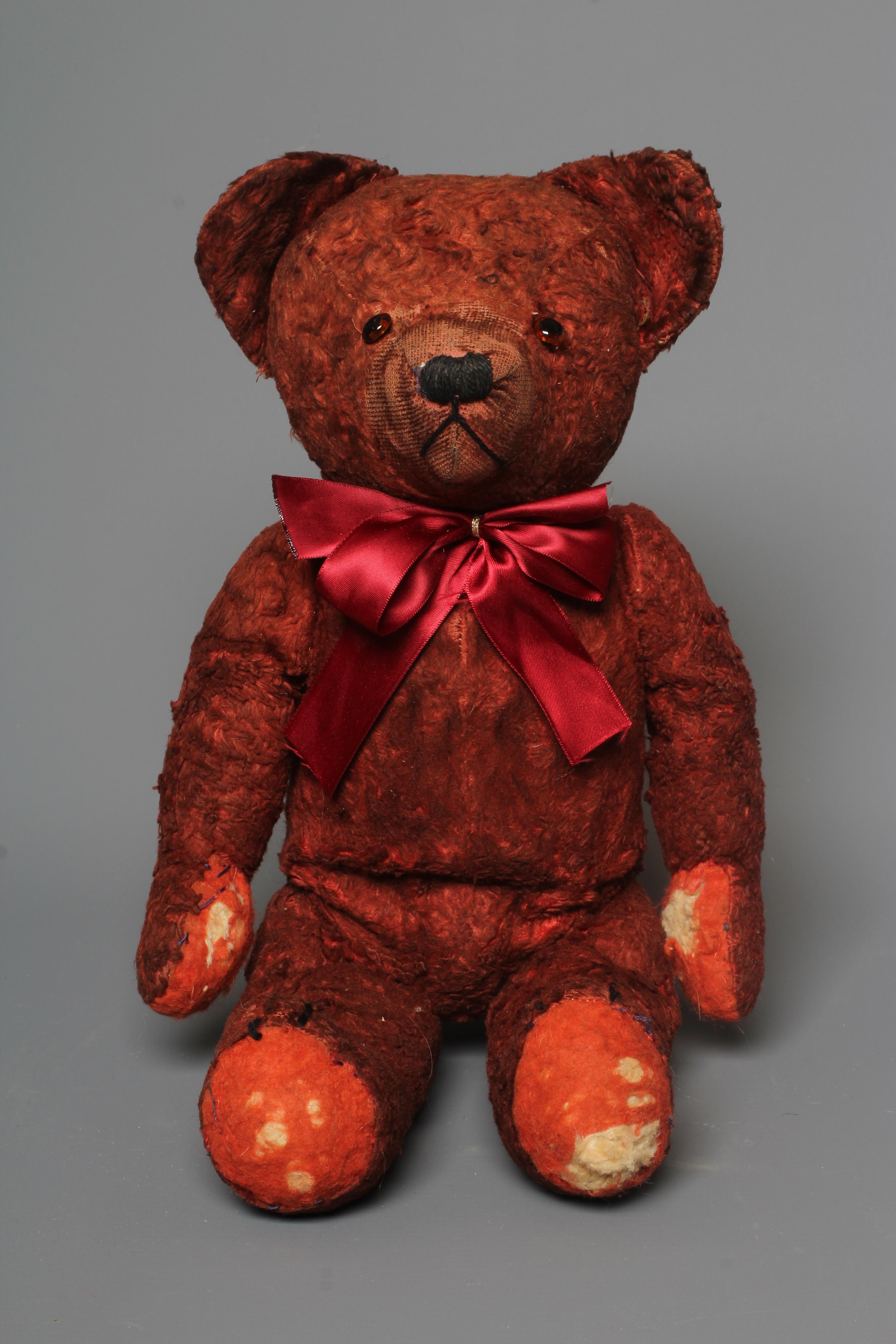 A pre-war red art silk teddy bear, possibly Chad Valley, with sewn nose, red glass eyes and felt Image