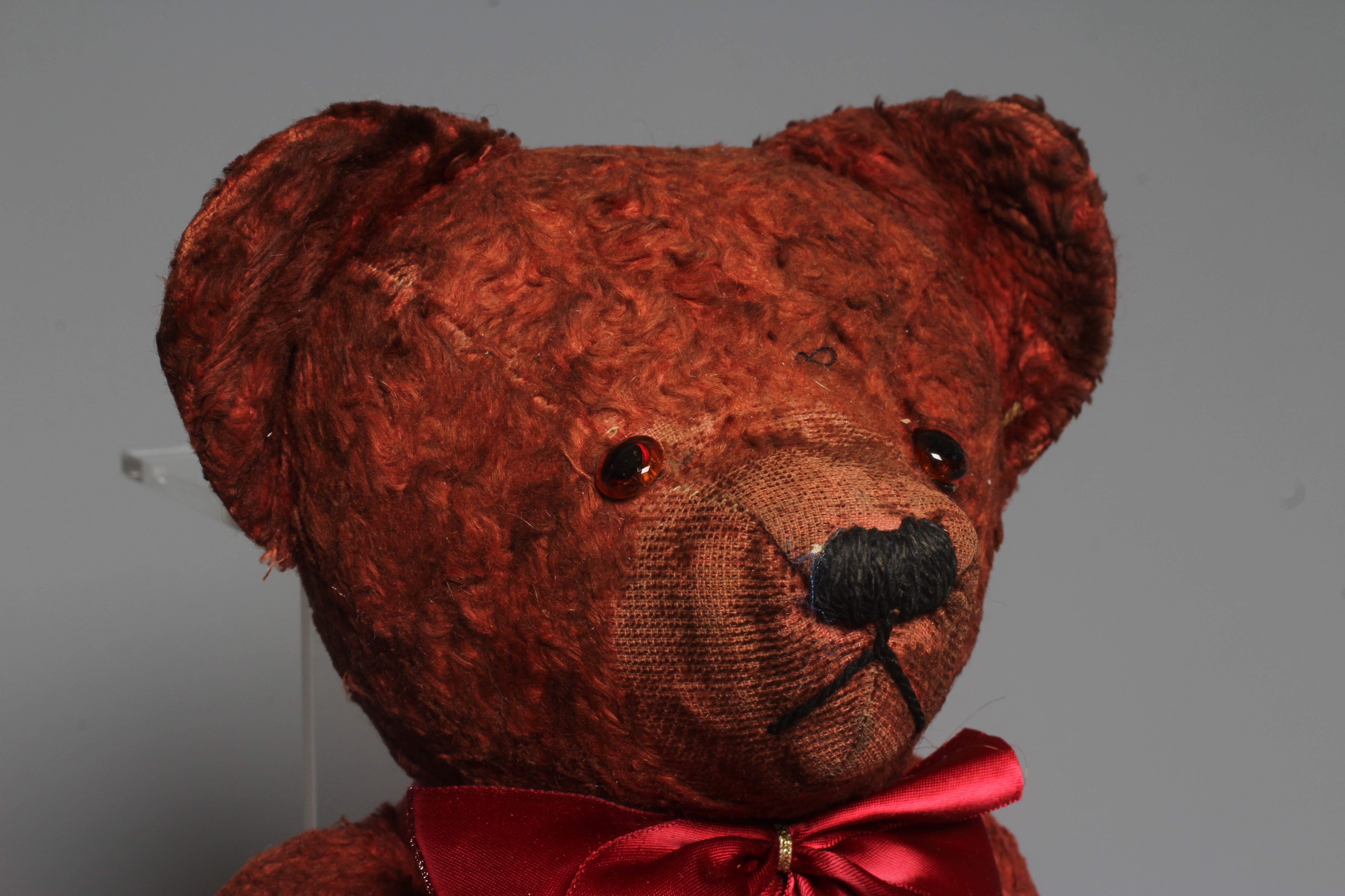 A pre-war red art silk teddy bear, possibly Chad Valley, with sewn nose, red glass eyes and felt Image