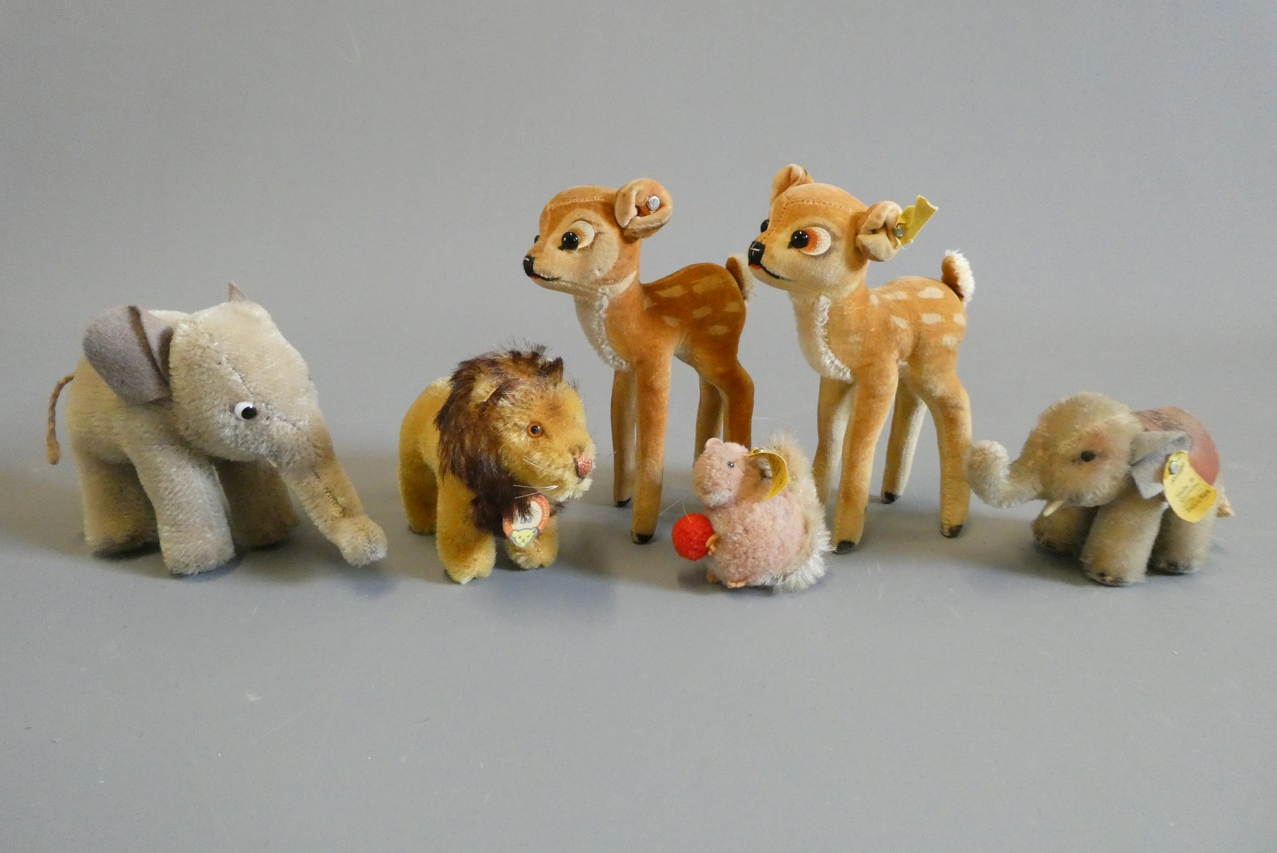 Six Steiff plush animals comprising two bambi's, two elephants, a Leo lion and a small squirrel Image
