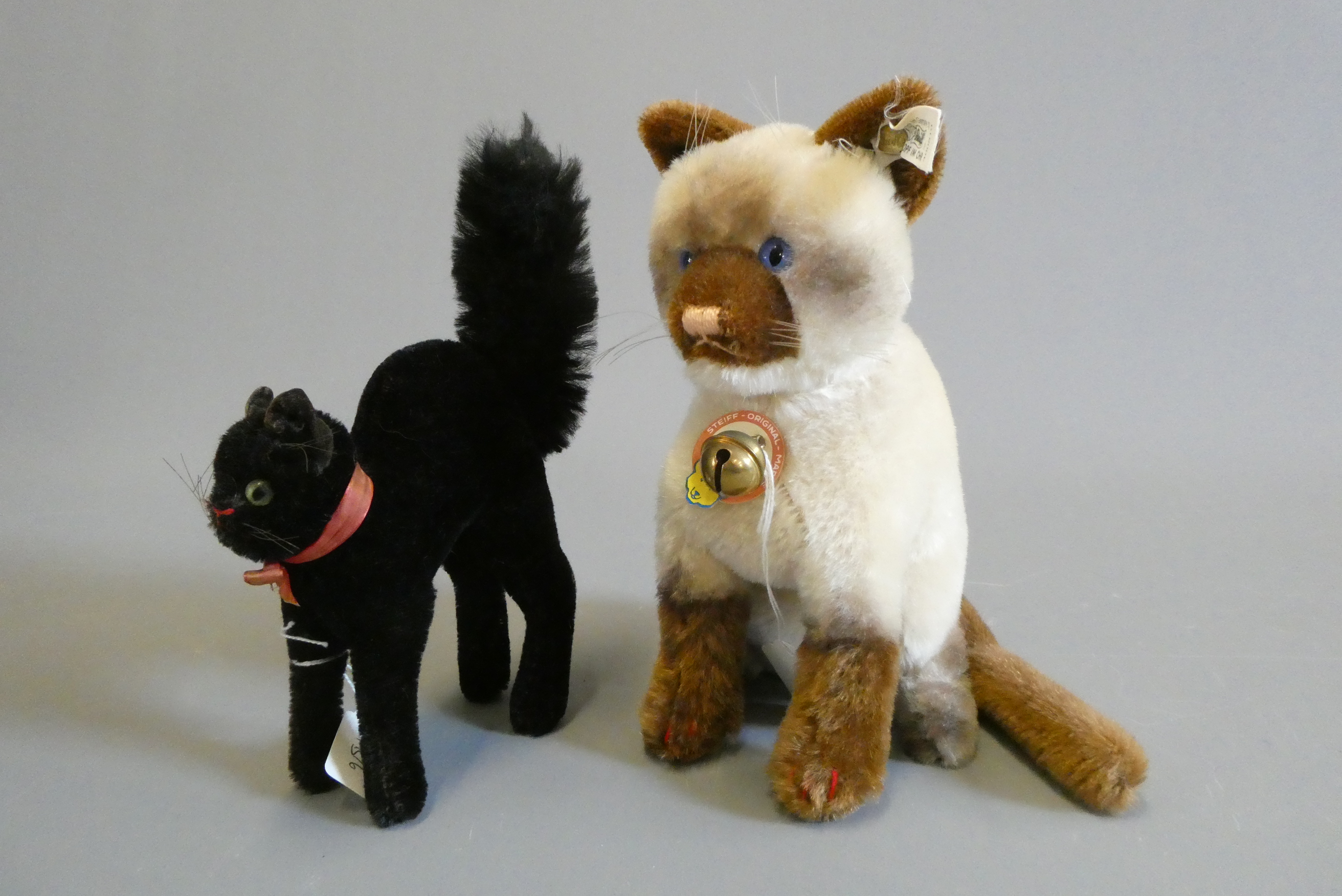 Two Steiff cats, comprising a limited edition Siamy 1930 replica and a scared black cat (Est. plus Image