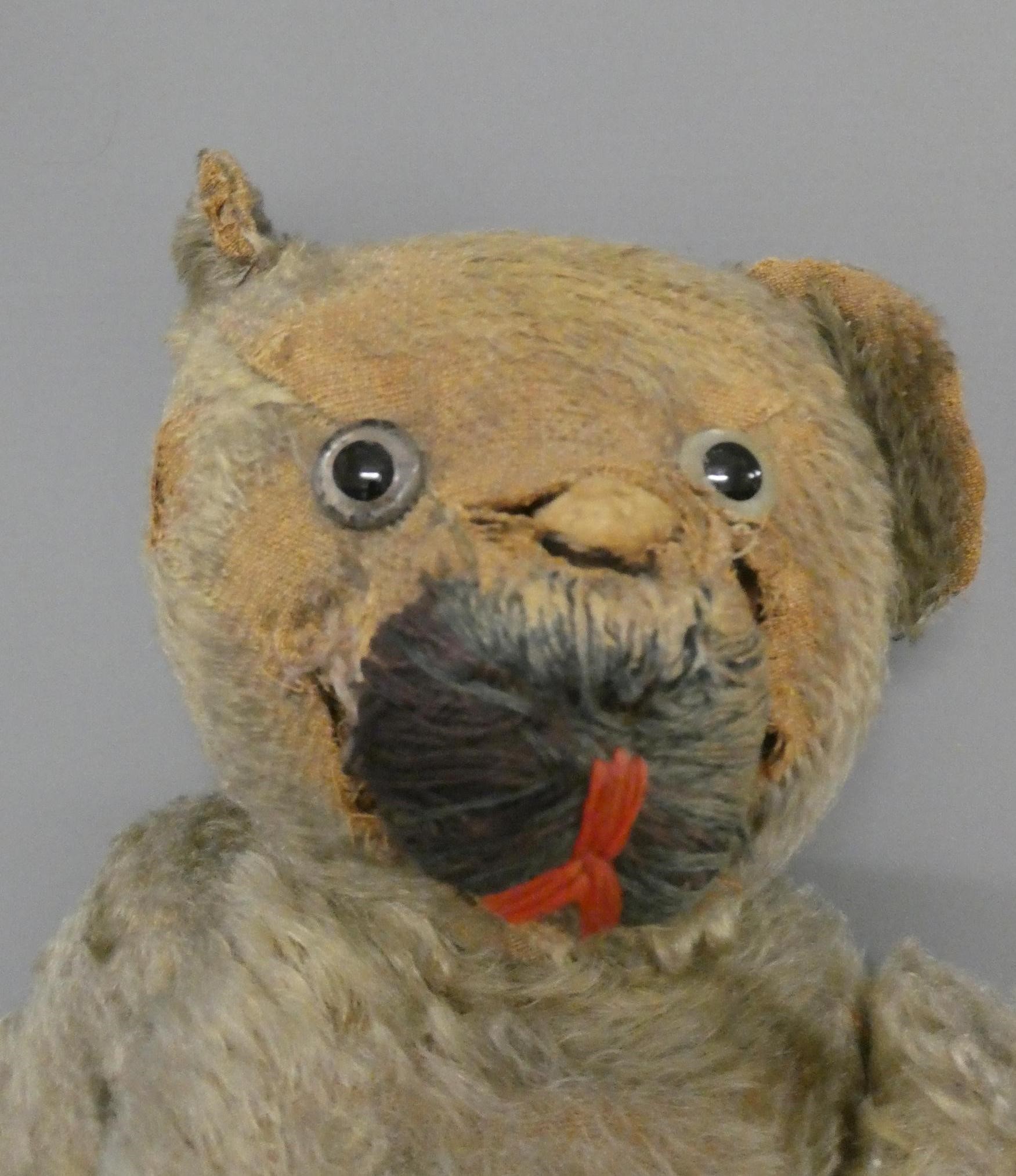 A pre-war teddy bear, with clear glass eyes, straw filling and hump back, 18" long (Est. plus 24% Image