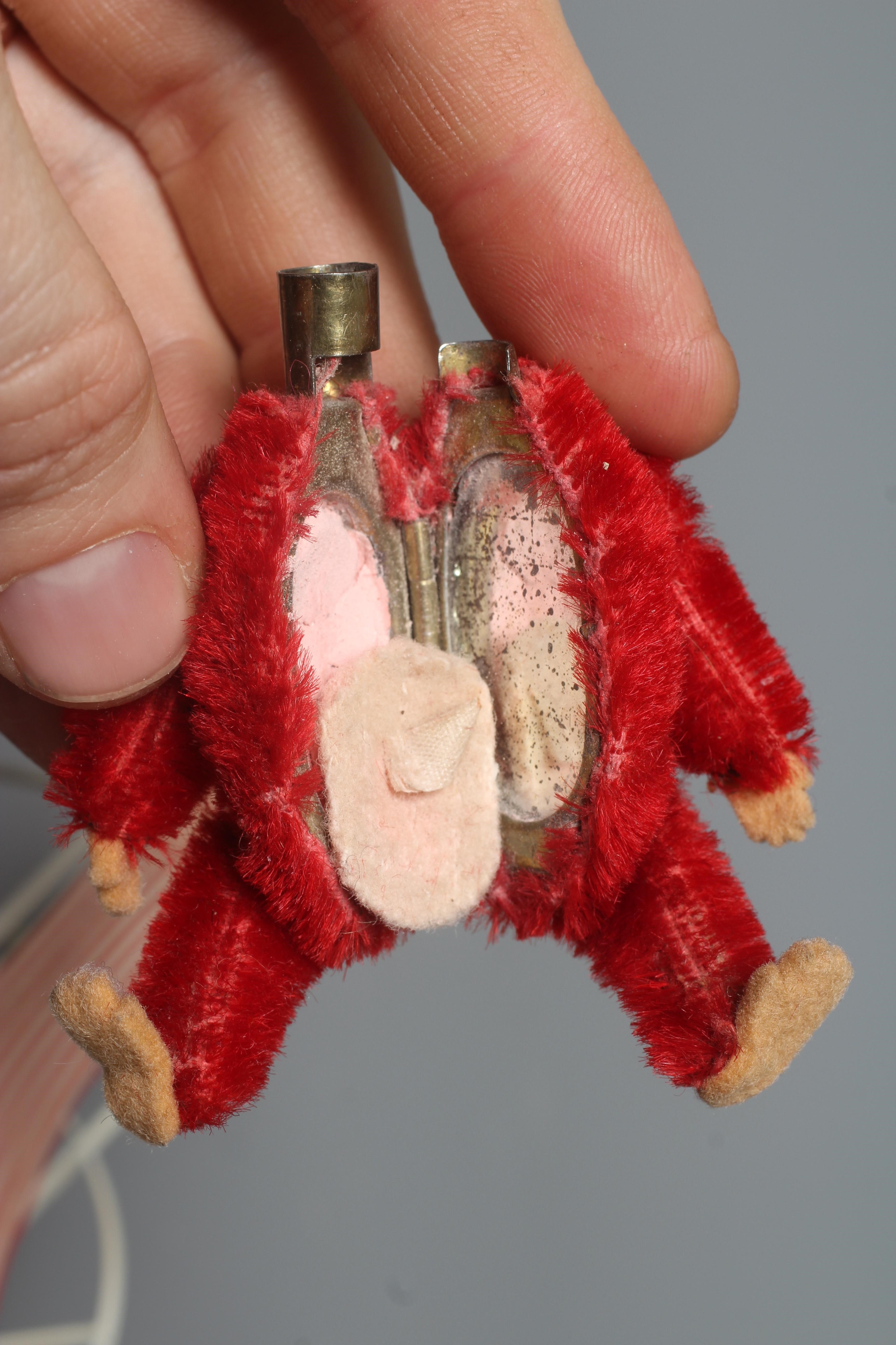 A rare Schuco red monkey compact, with felt hands and feet, powder puff and associated deckchair, Image