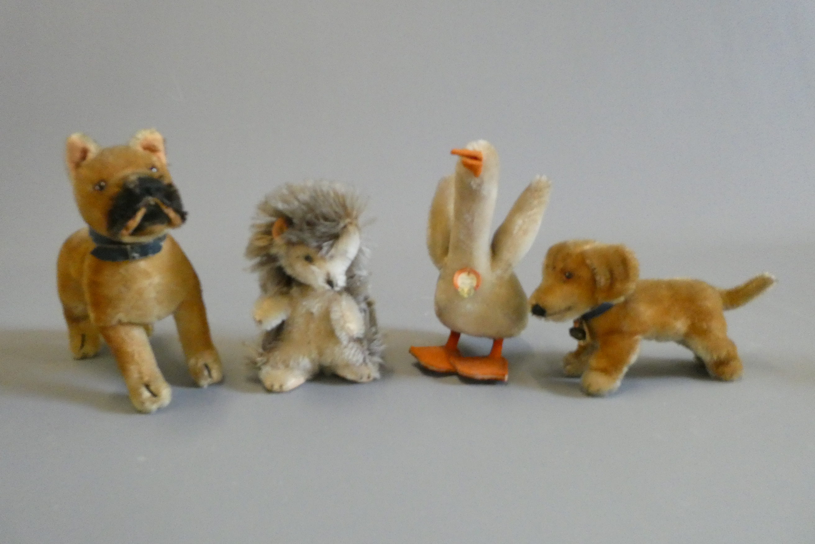 Four Steiff animals, comprising a goose, a hedgehog, a dog and Bazi (Est. plus 24% buyer's premium Image